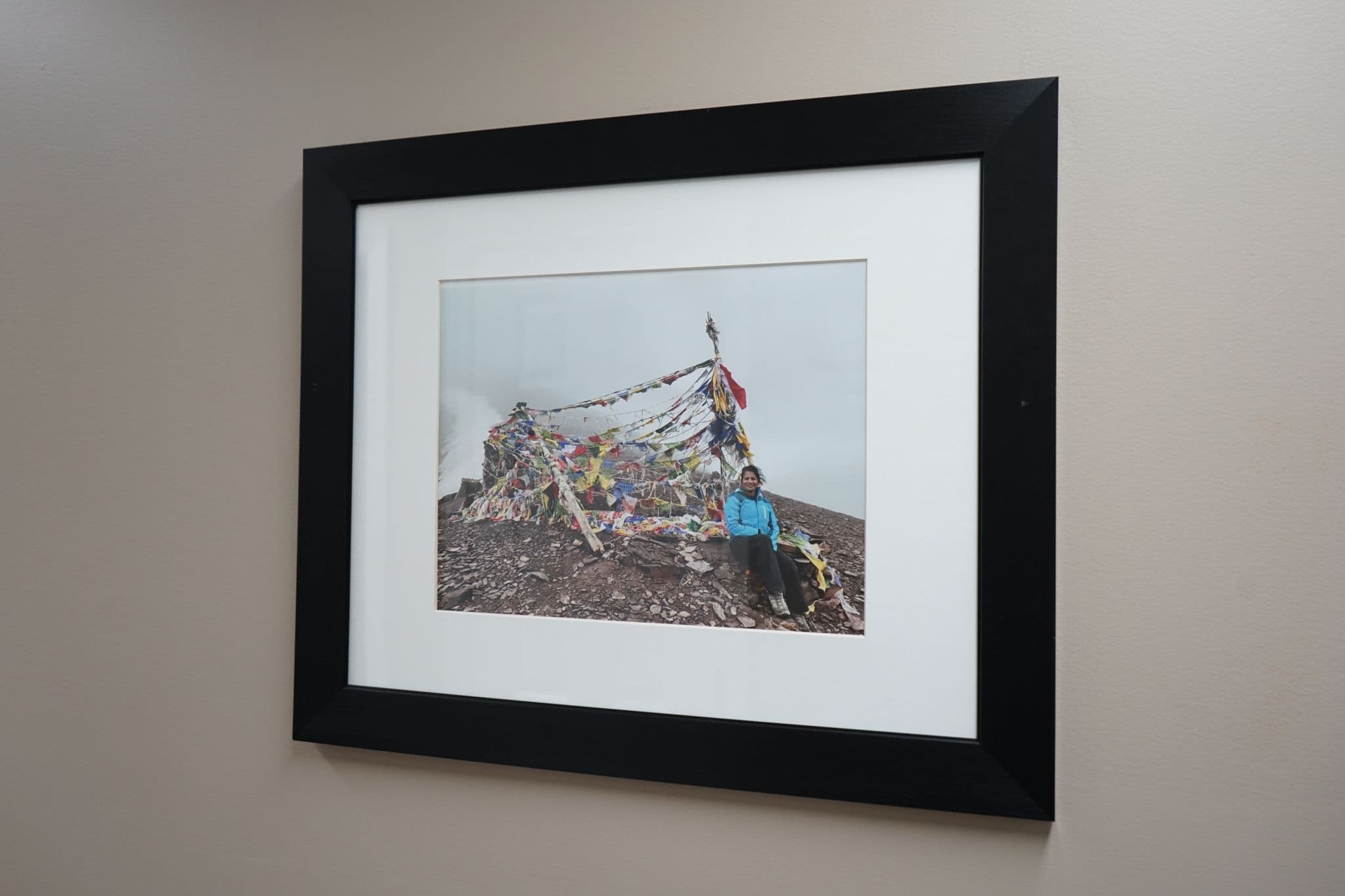 a framed picture of Dr. Prasad sitting on top of a mountain at South Georgia Internal Medicine at Swainsboro .