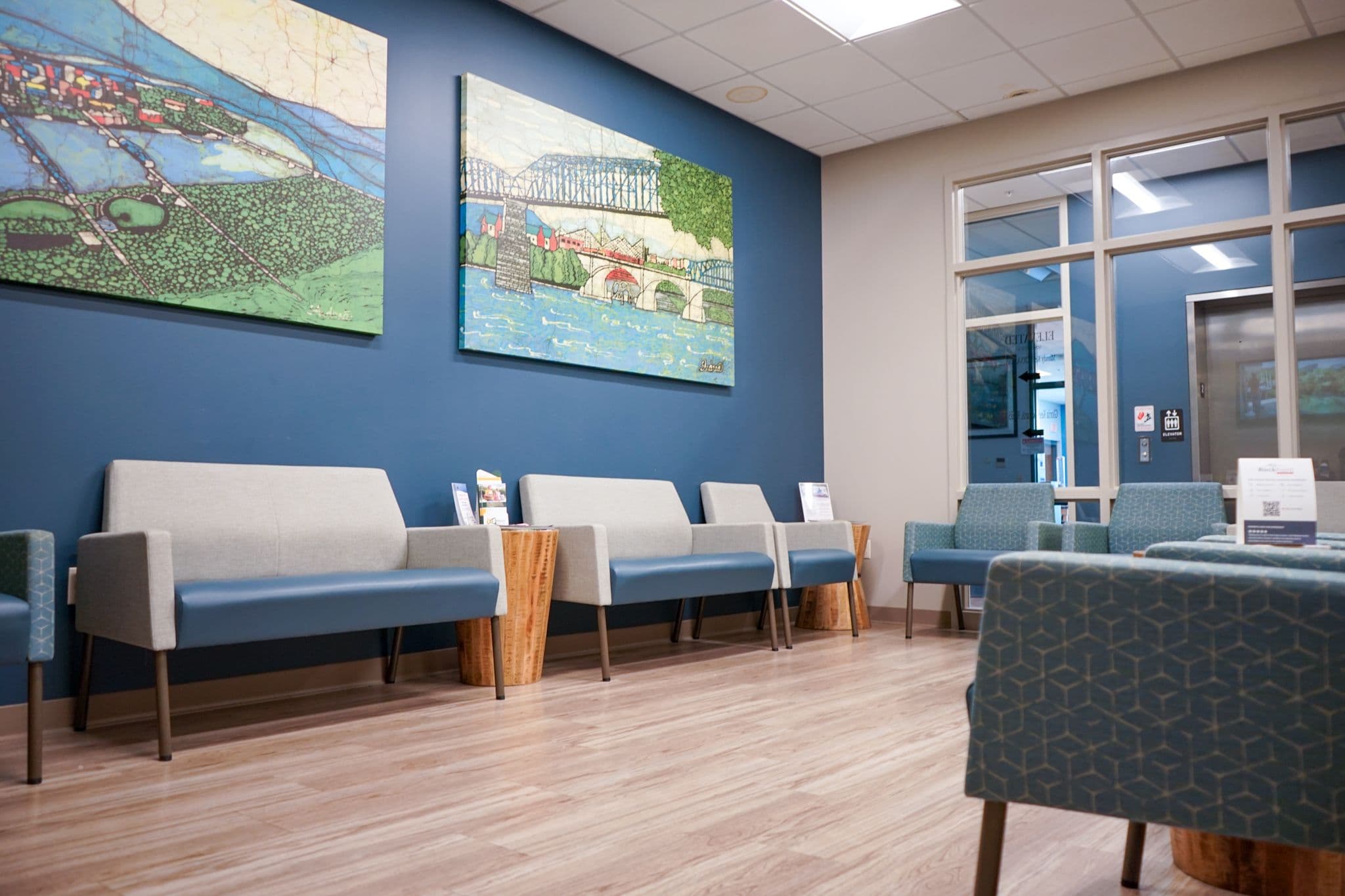 Restore Health & Wellness waiting room with a lot of chairs and a painting on the wall .