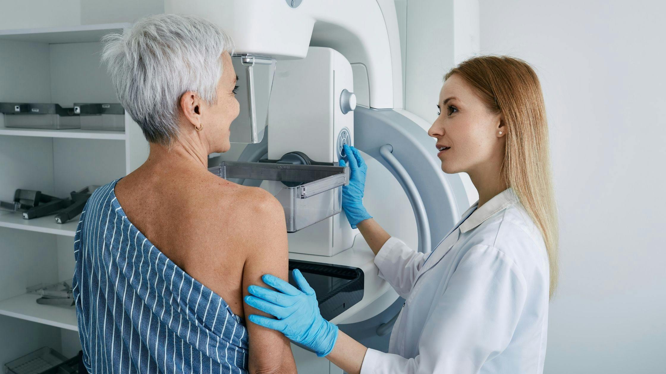a woman is getting a mammogram from a doctor .