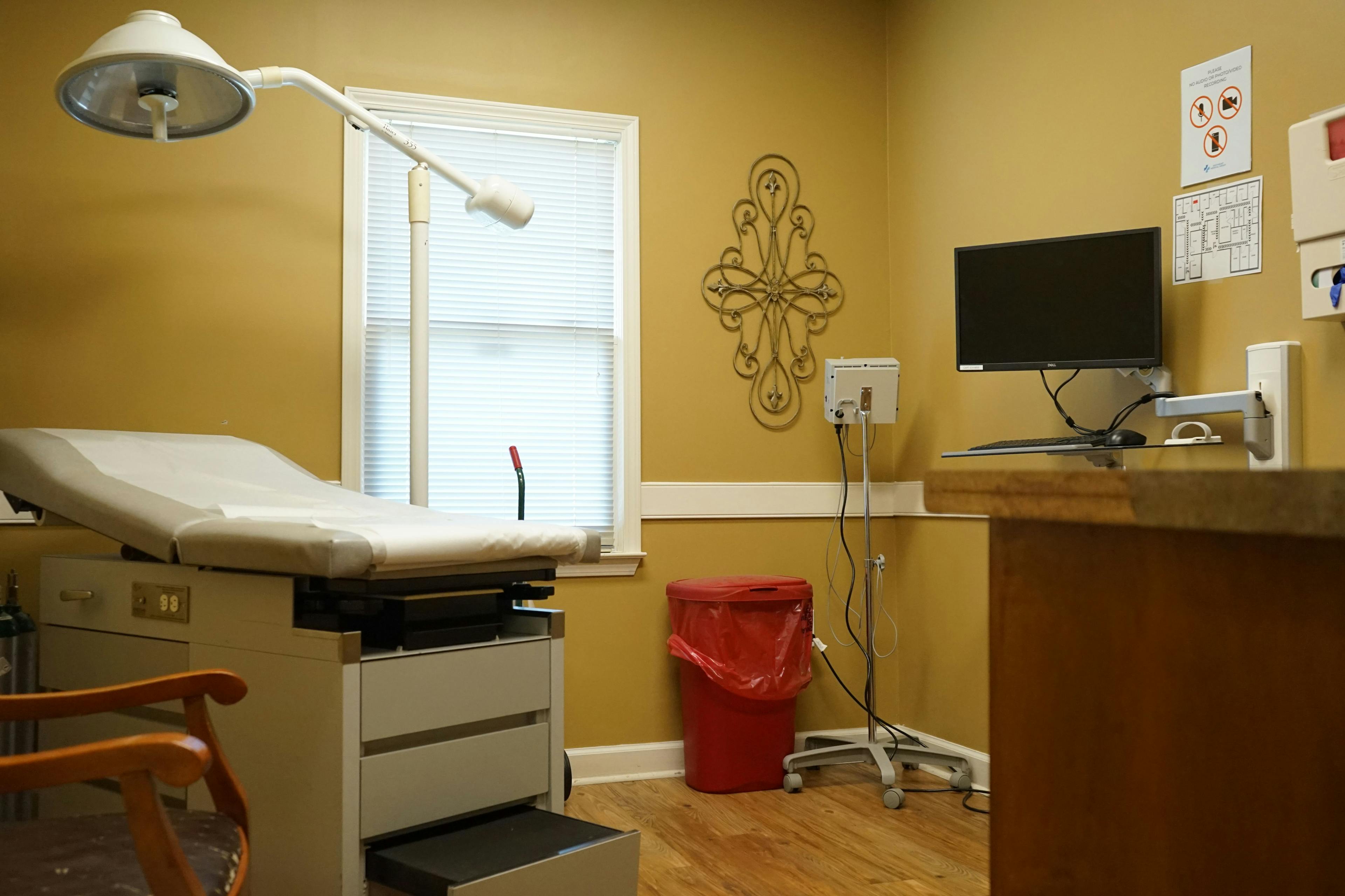 a doctor 's office with a examination table and a computer .