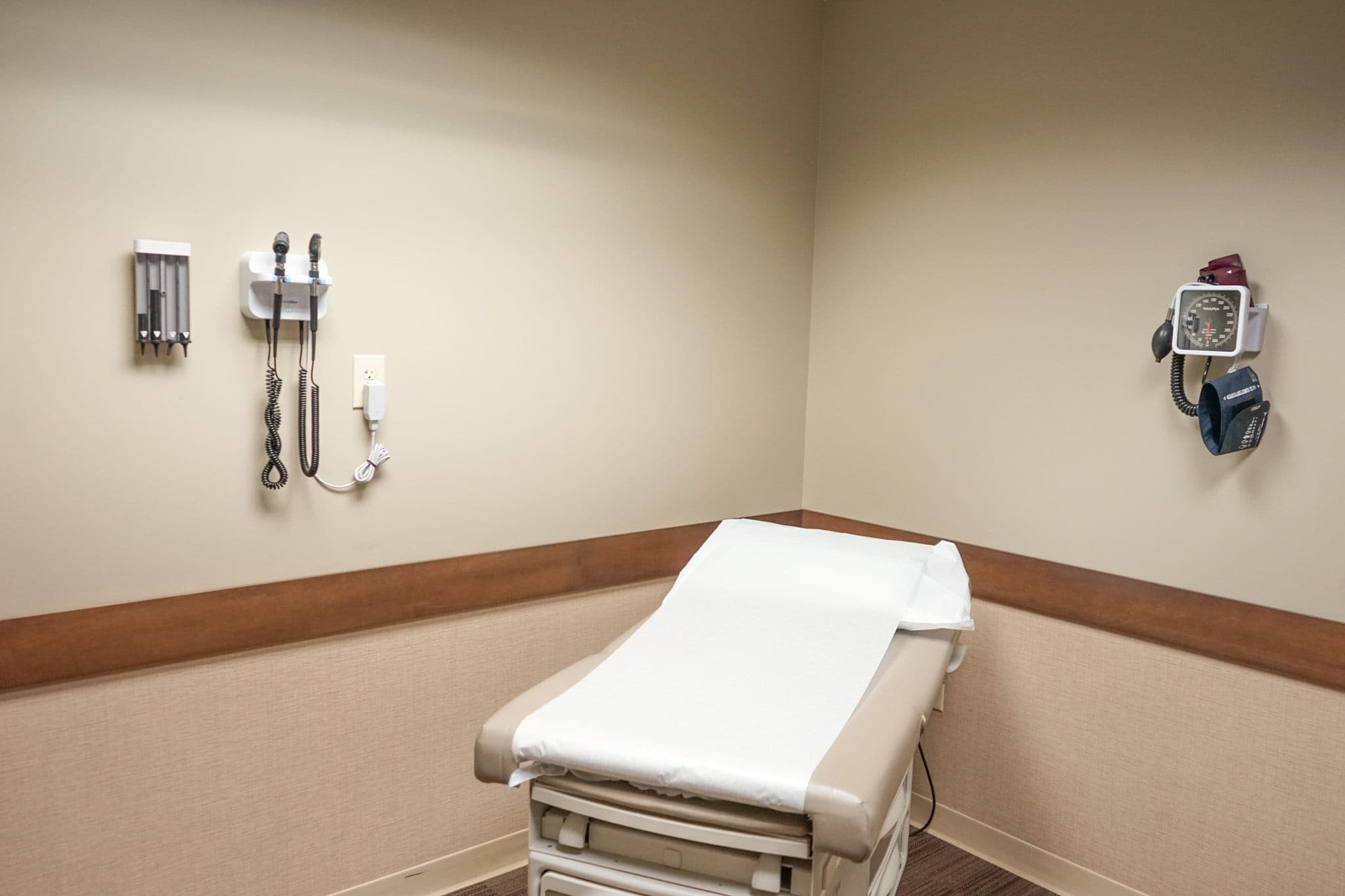 a doctor 's office with a bed and a stethoscope on the wall .