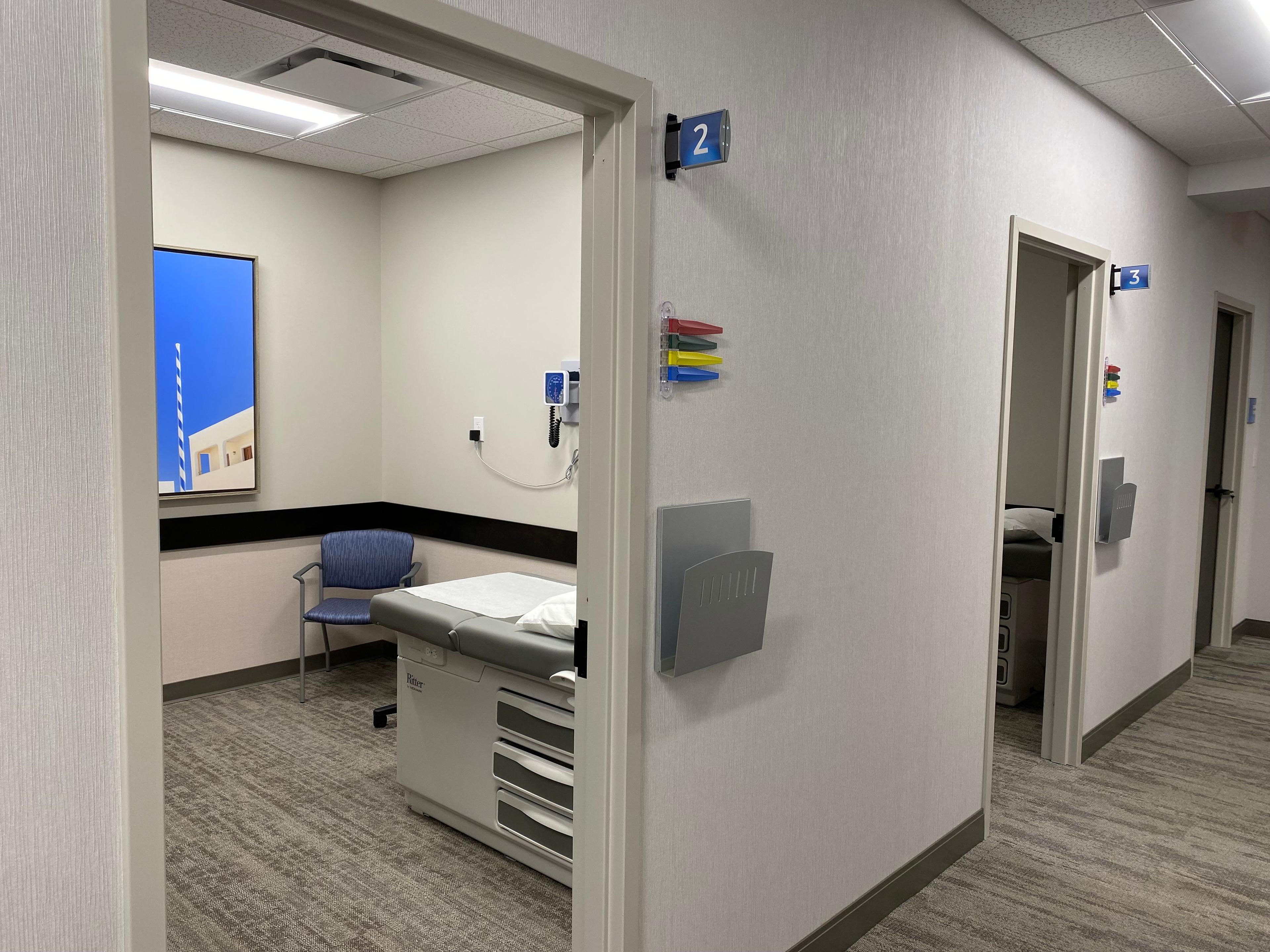 a doctor 's office with a table and chairs in a hallway .