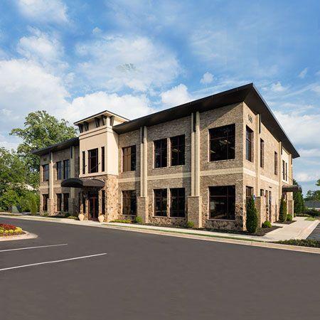 a large brick building with a lot of windows and a parking lot in front of it .