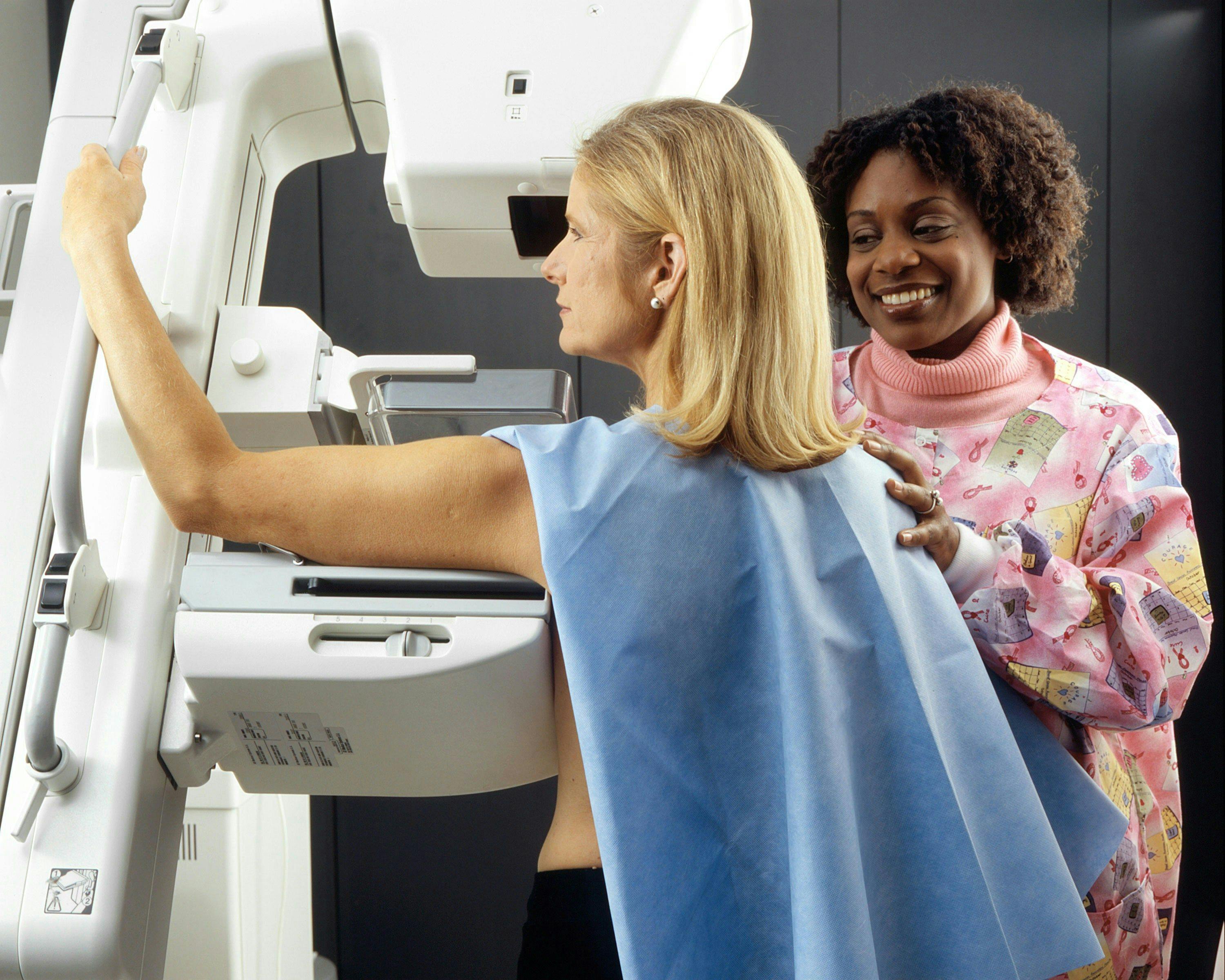 a woman is getting a mammogram from a nurse .