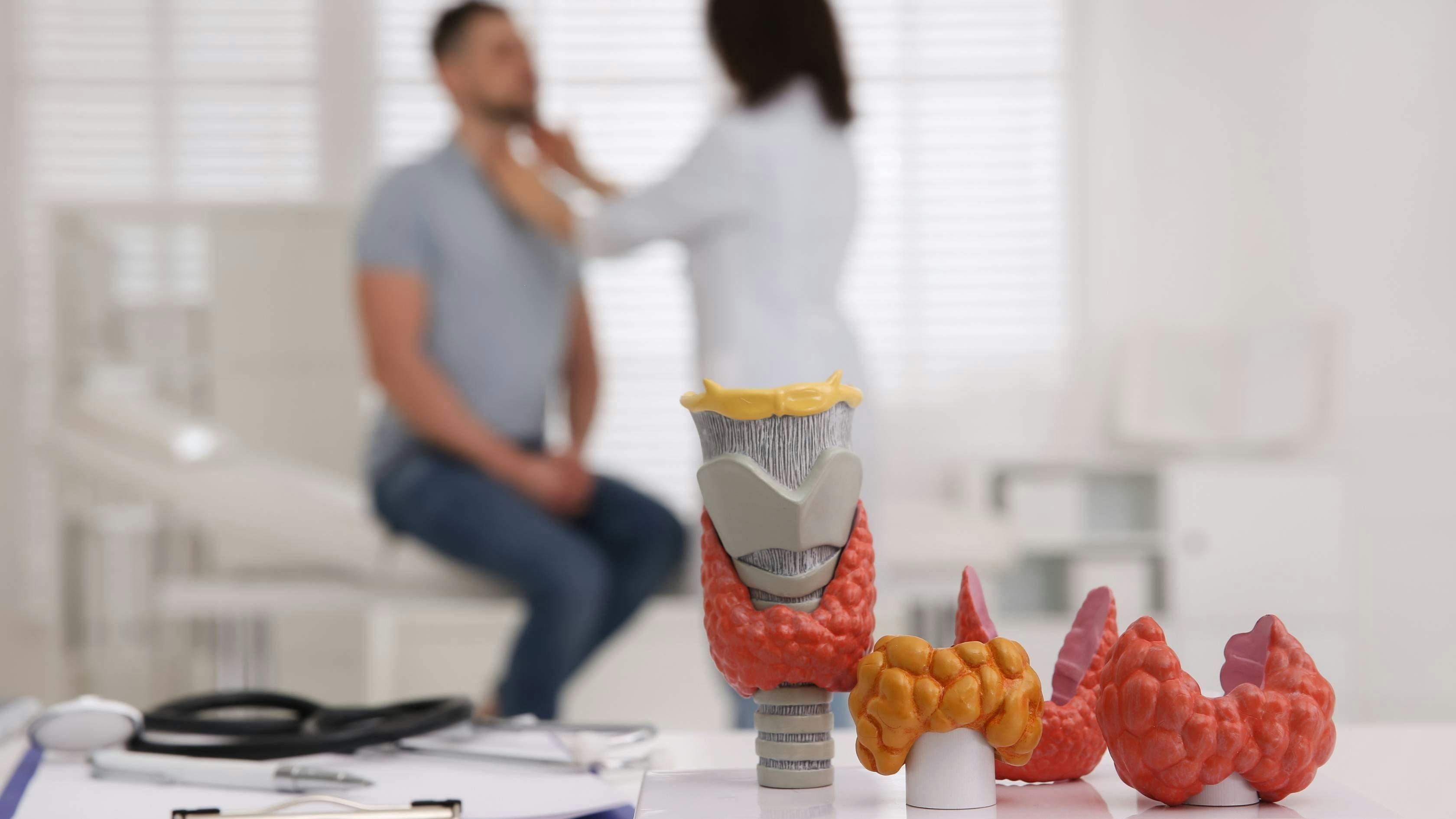 a doctor is examining a patient 's thyroid in a hospital .