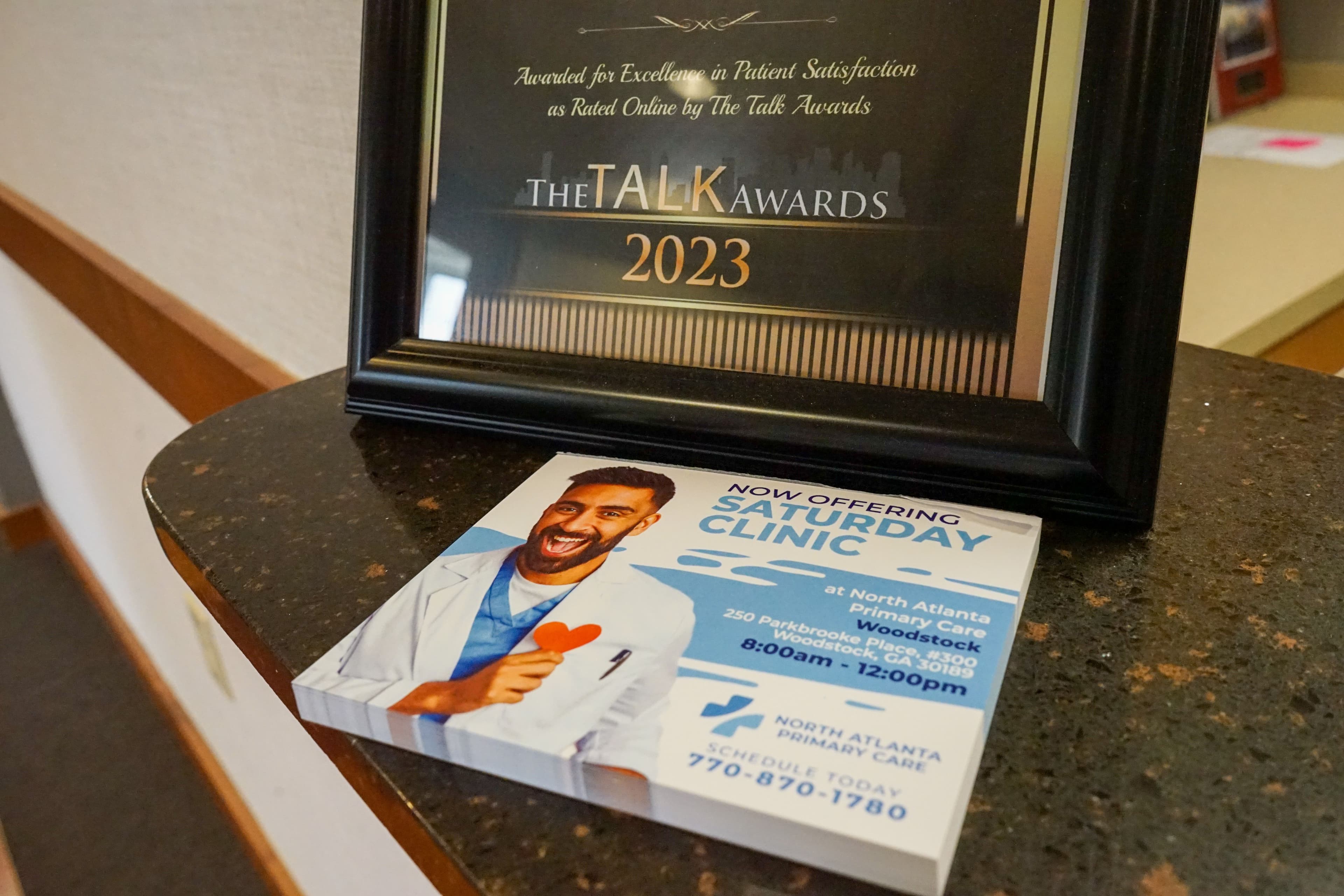 a framed certificate is sitting on top of a counter next to a flyer .