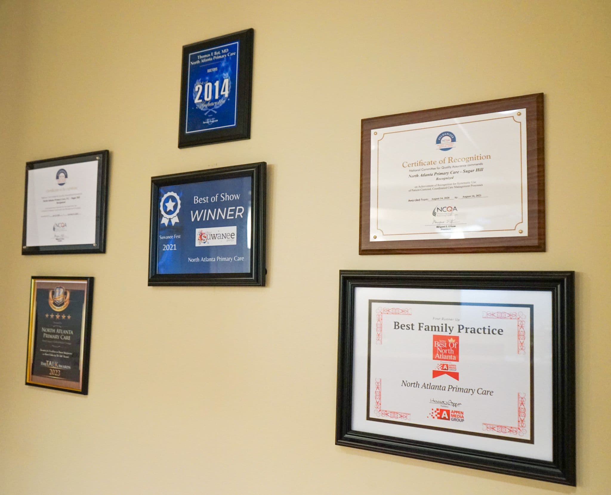 a wall with a bunch of awards hanging on it .