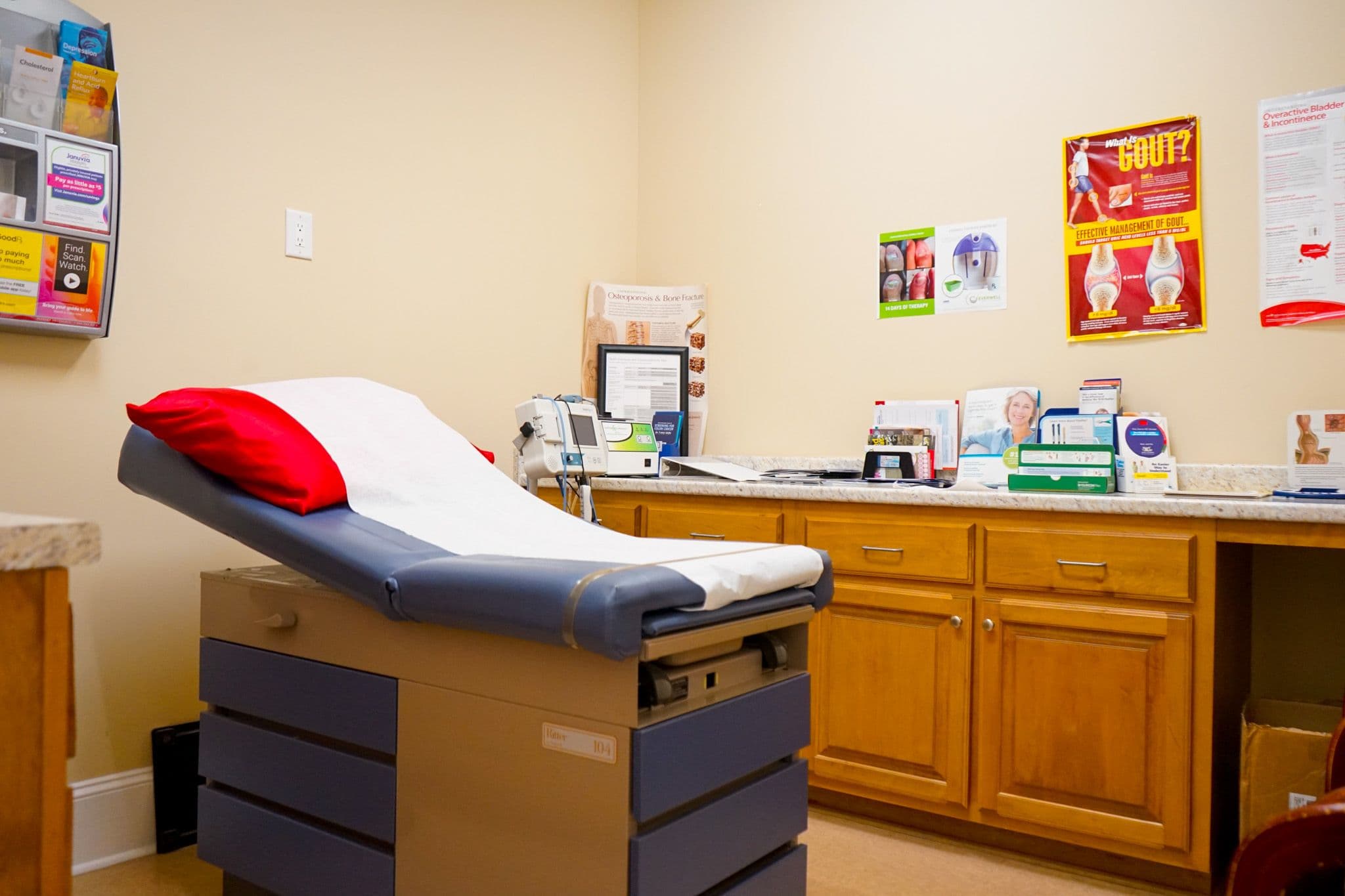 Perry Primary Care doctor 's office with a examination table and cabinets .