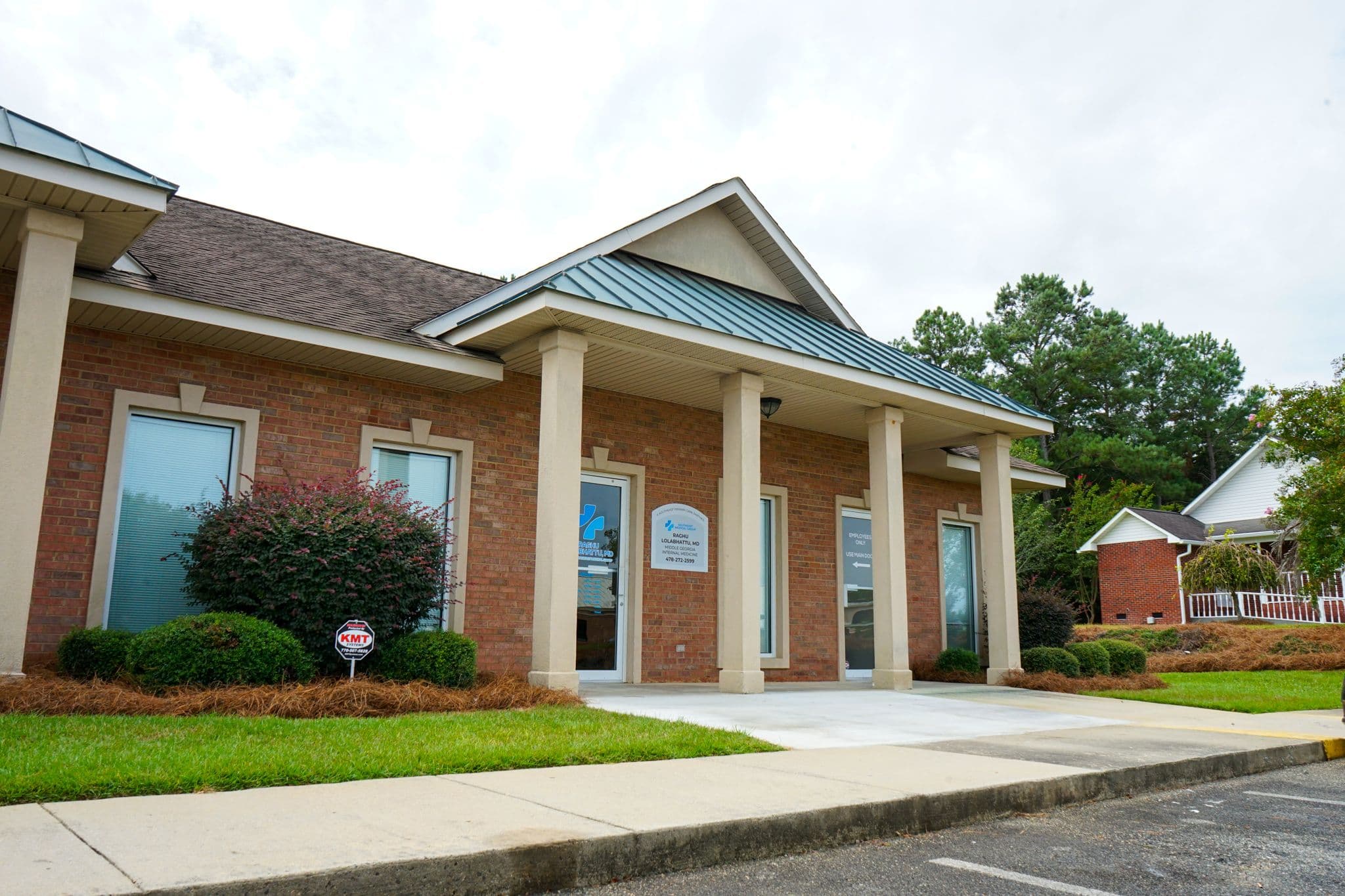 Middle Georgia Internal Medicine building with a metal roof is sitting next to a parking lot .