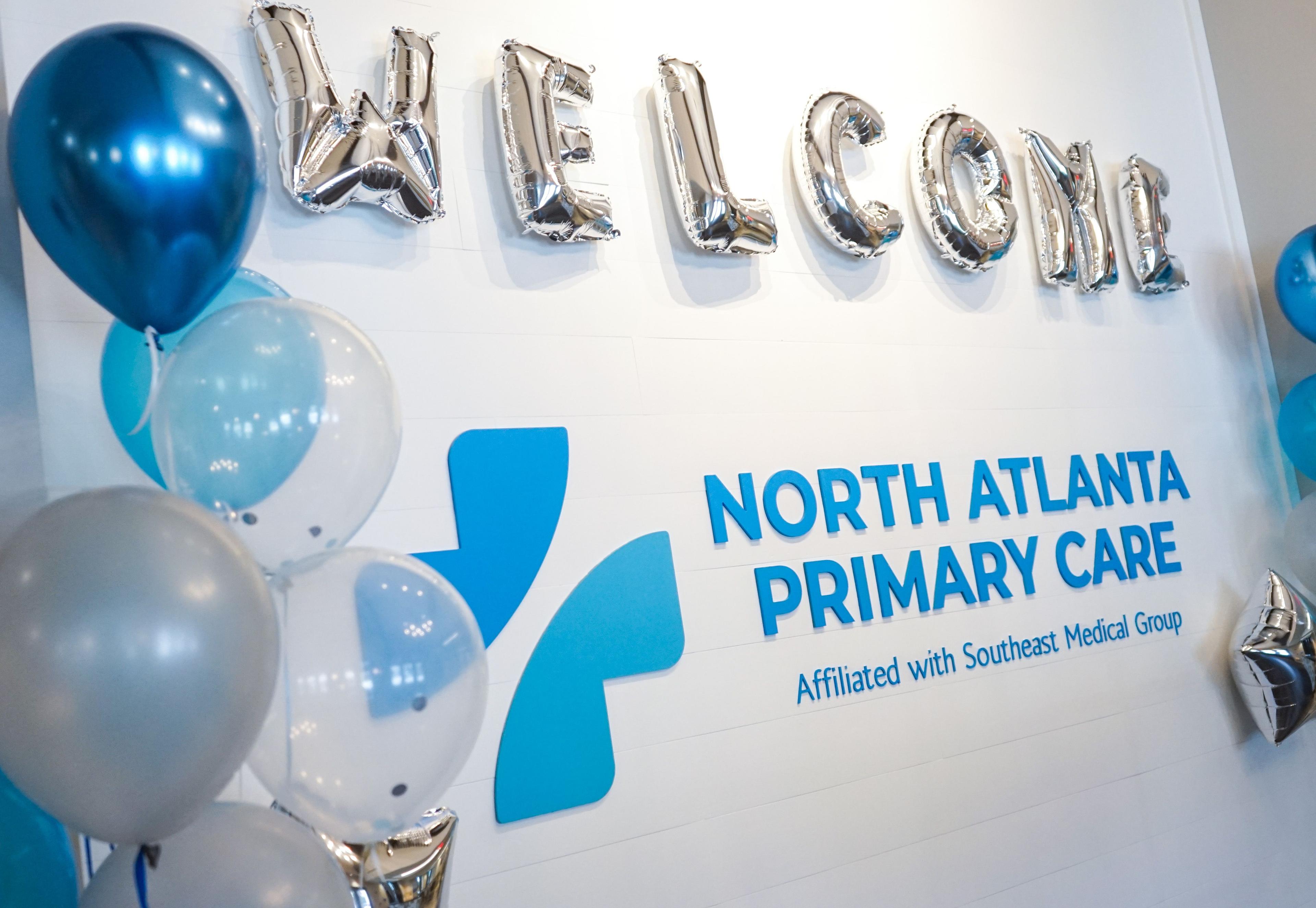 a welcome sign for north atlanta primary care is surrounded by balloons .