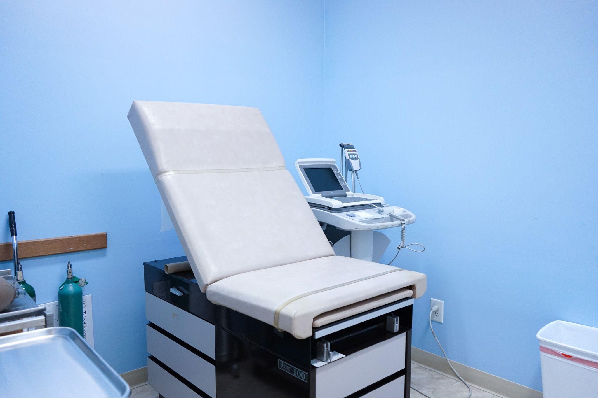 a doctor 's office with a chair and an ultrasound machine .