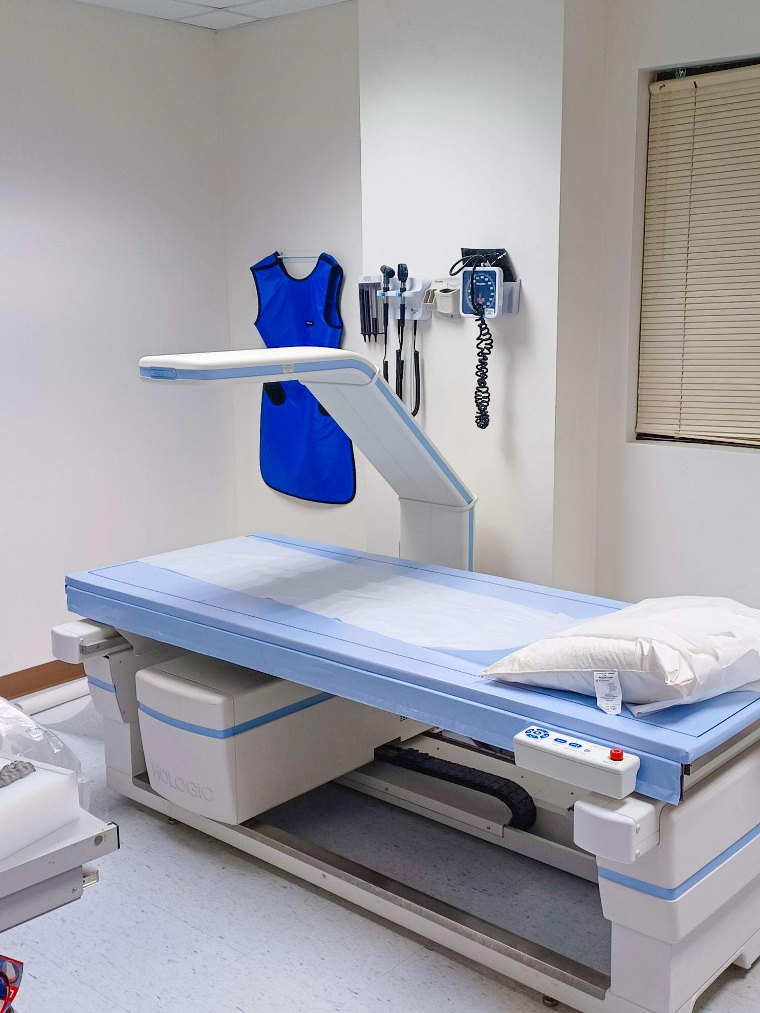 a hospital room with a bed and a x-ray machine