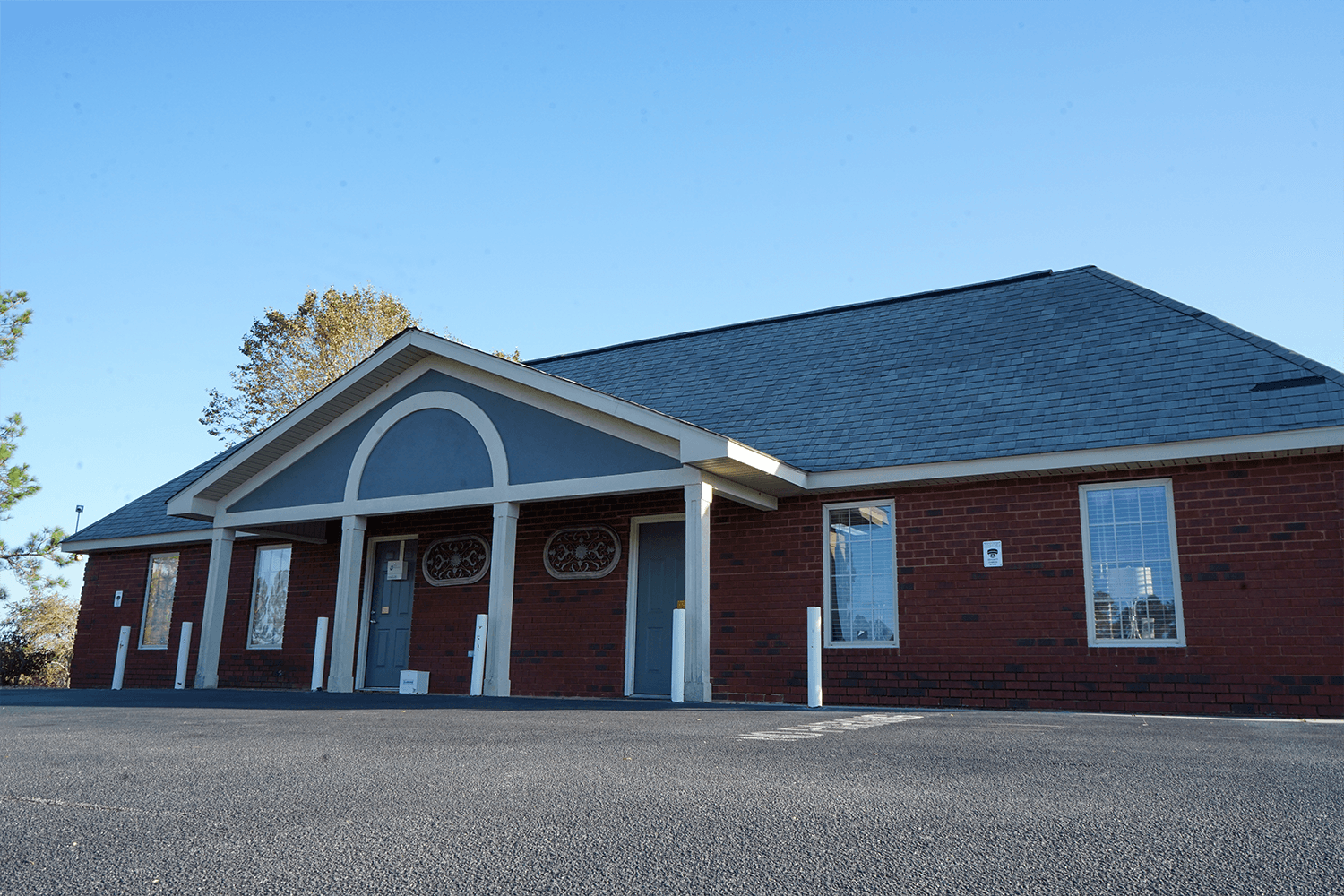 a brick building with a gray roof and a sign that says ' ambulance ' on it