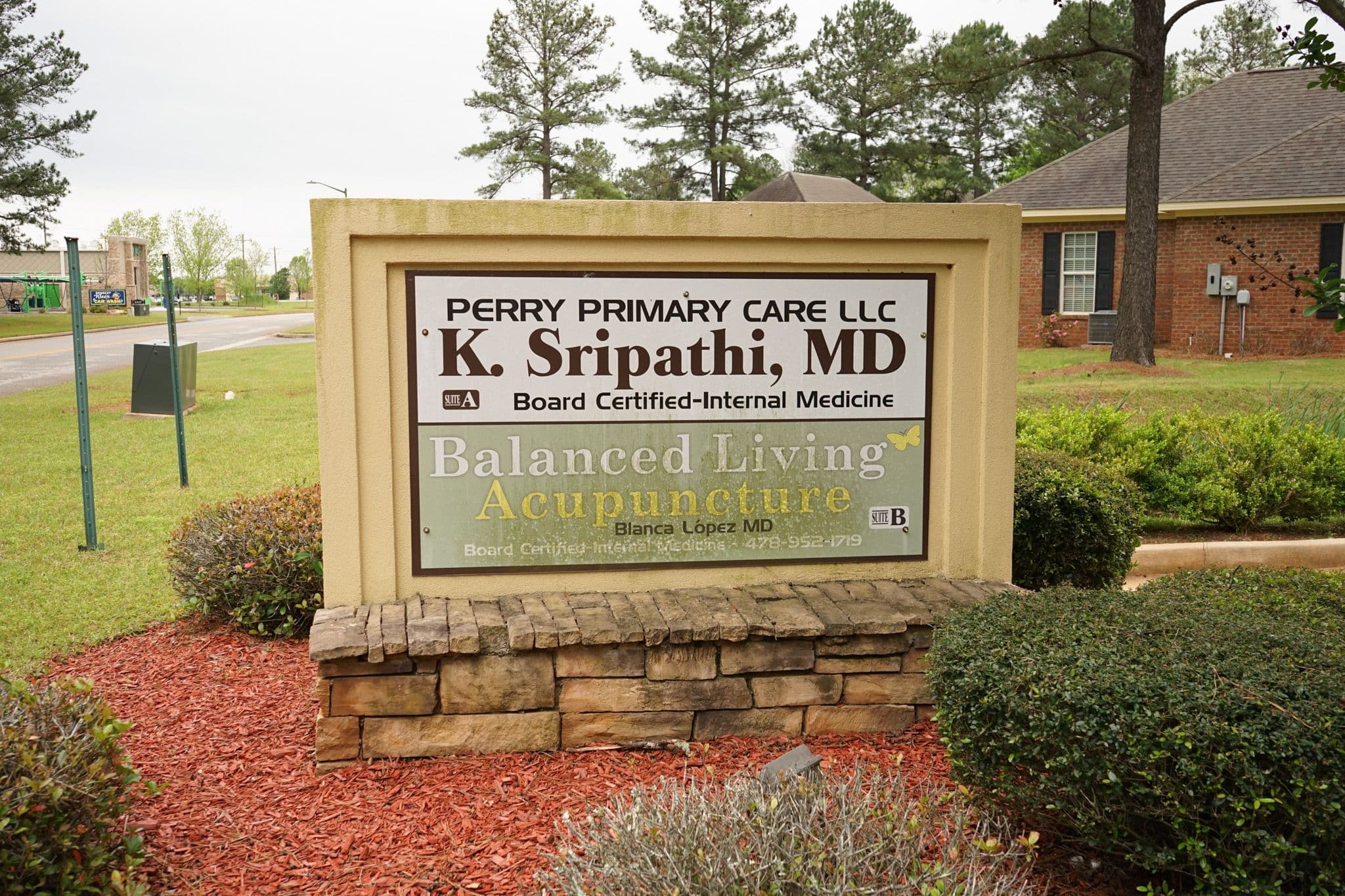 a sign for Perry Primary Care and Dr. Karunaker Sripathi , MD .