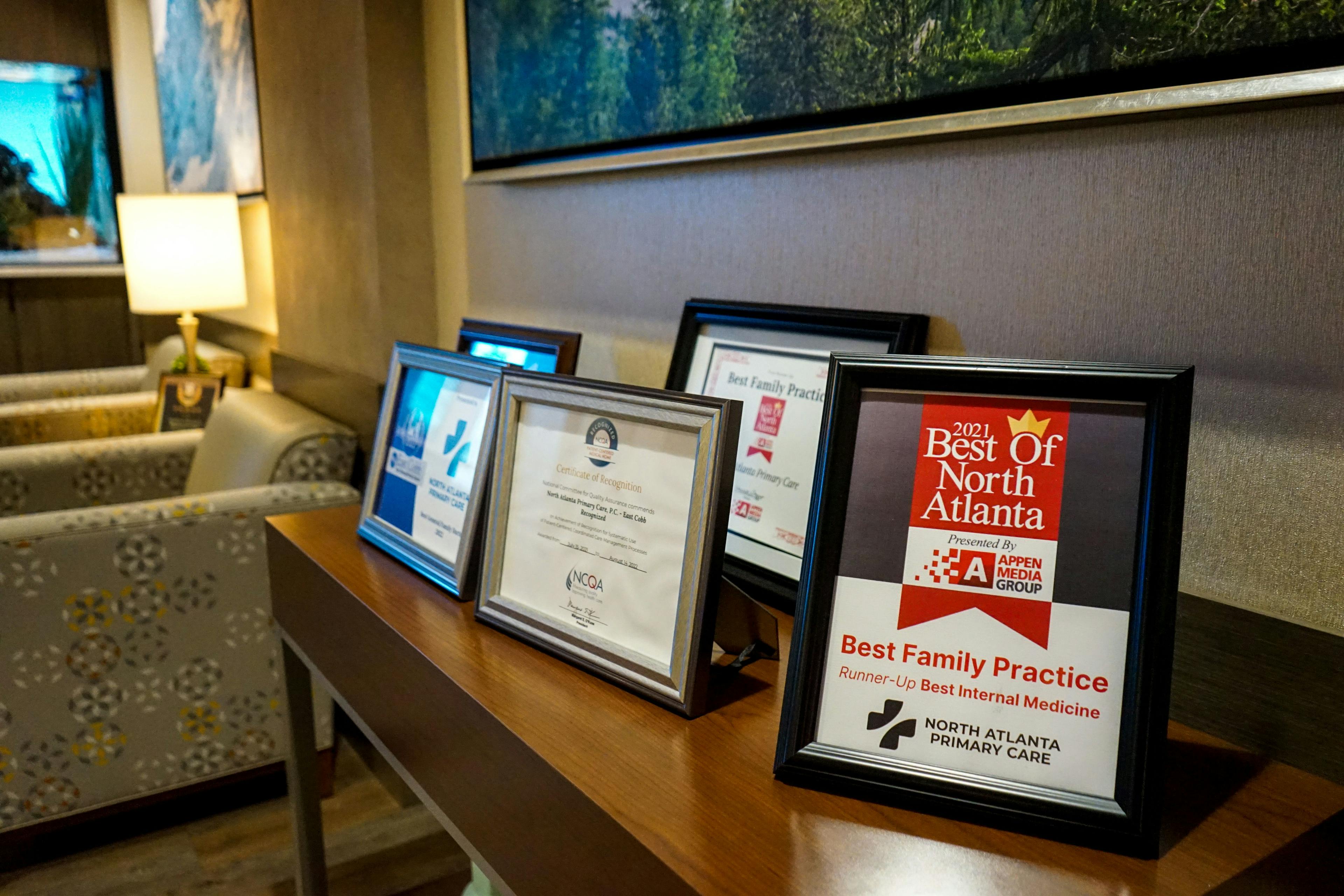 a row of framed certificates are sitting on a wooden table .