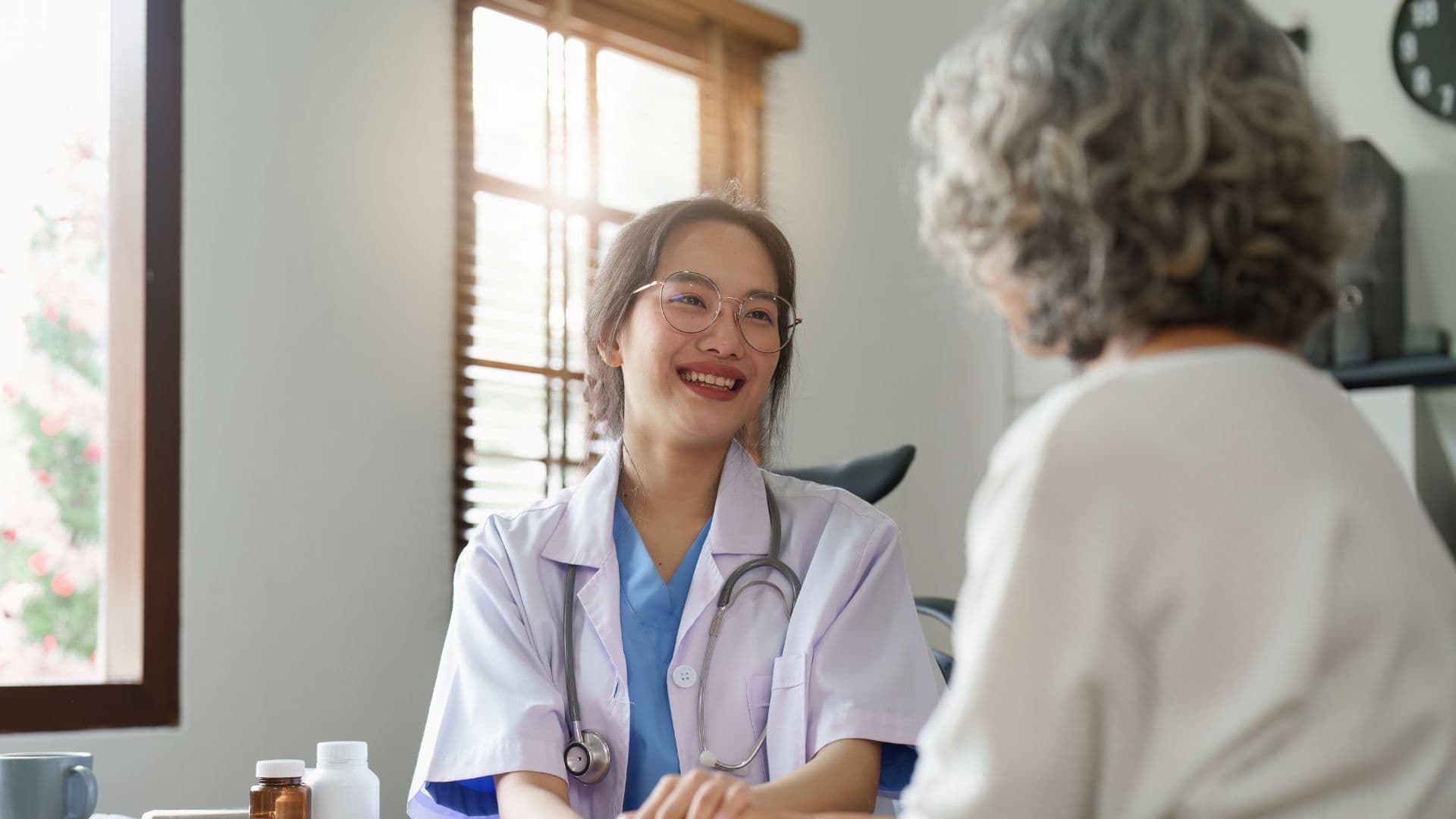 a doctor is talking to an elderly woman in a hospital room .