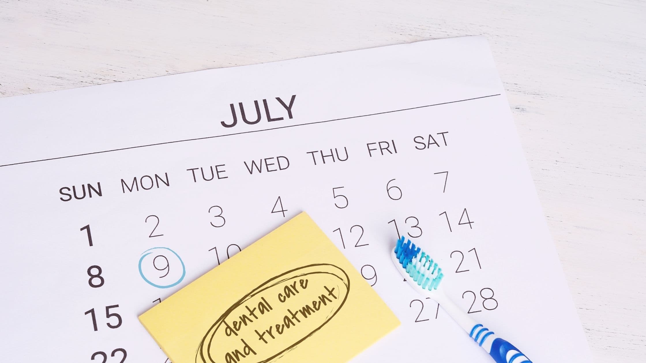 a calendar with a toothbrush and a sticky note on it .