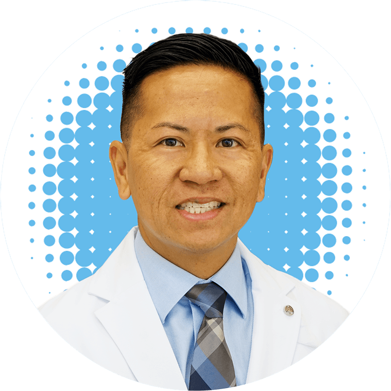 Dr. Richard L. Antonio, MD, in a white coat and tie smiles for the camera