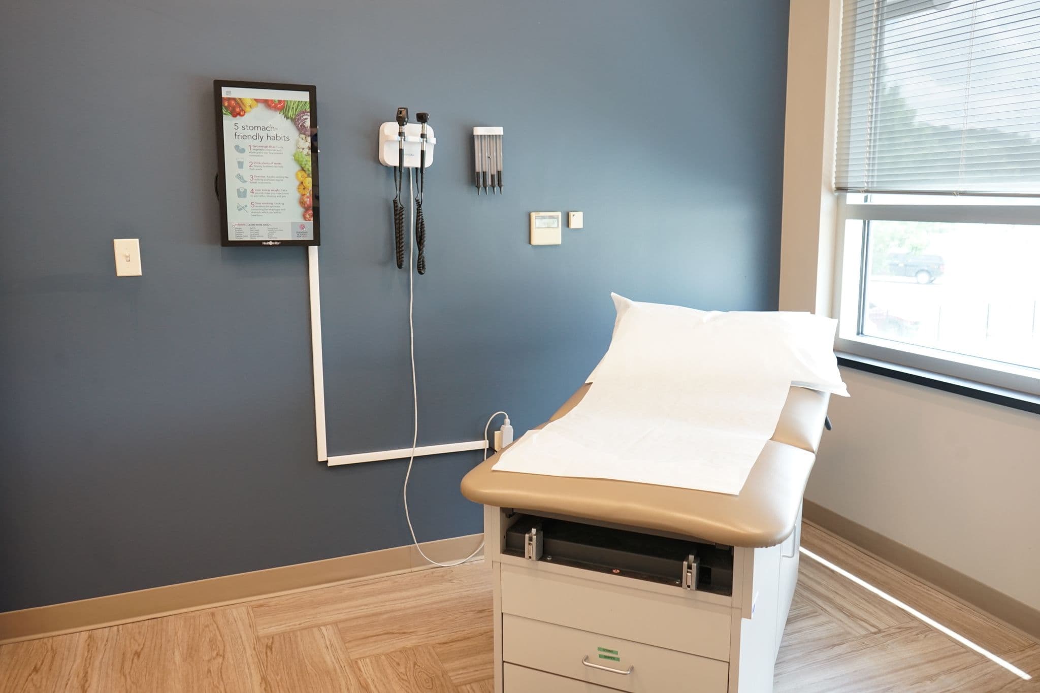 Restore Health & Wellness exam room with a bed and a window .