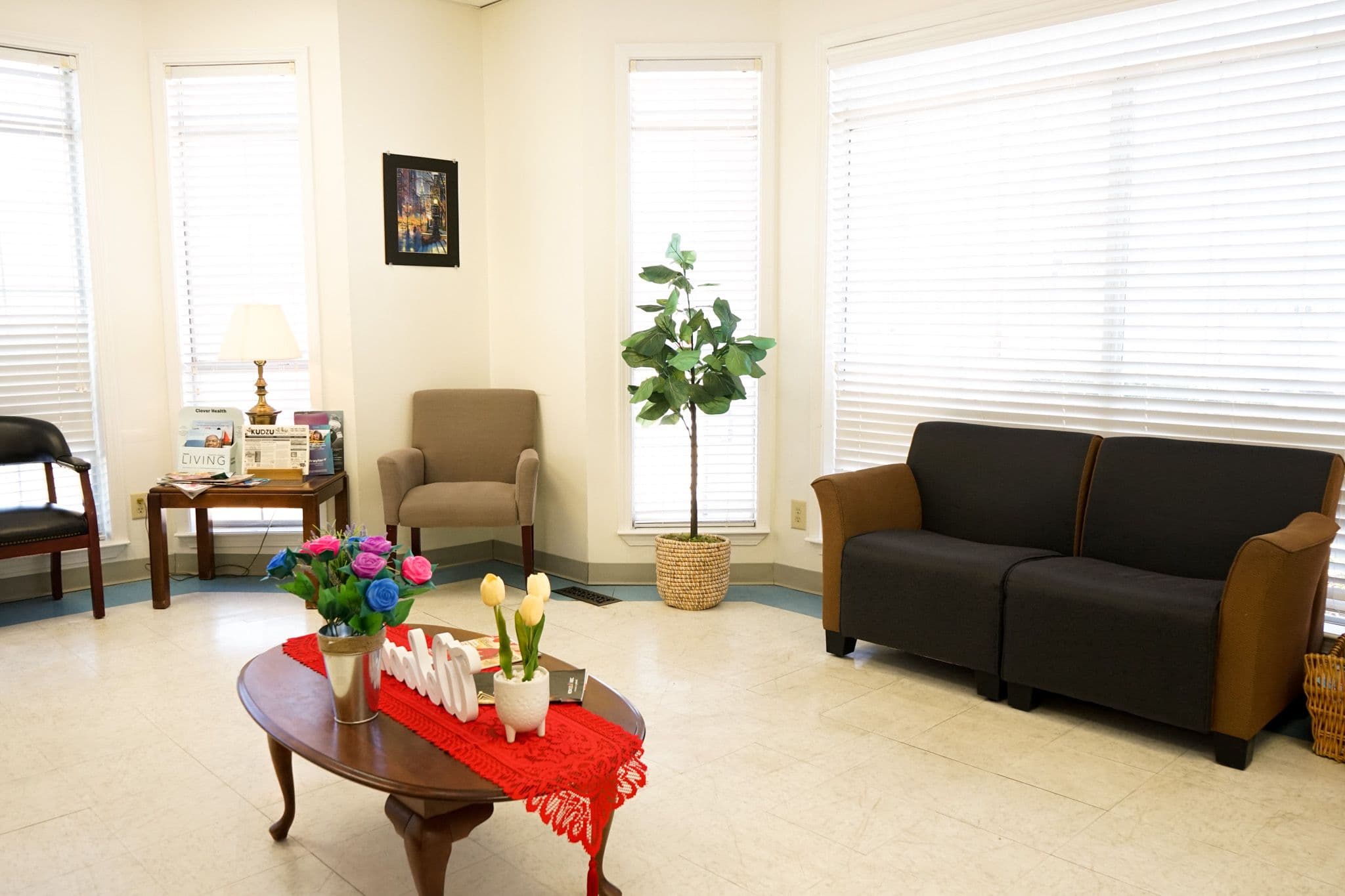 a waiting room with a couch , chairs , and a coffee table .