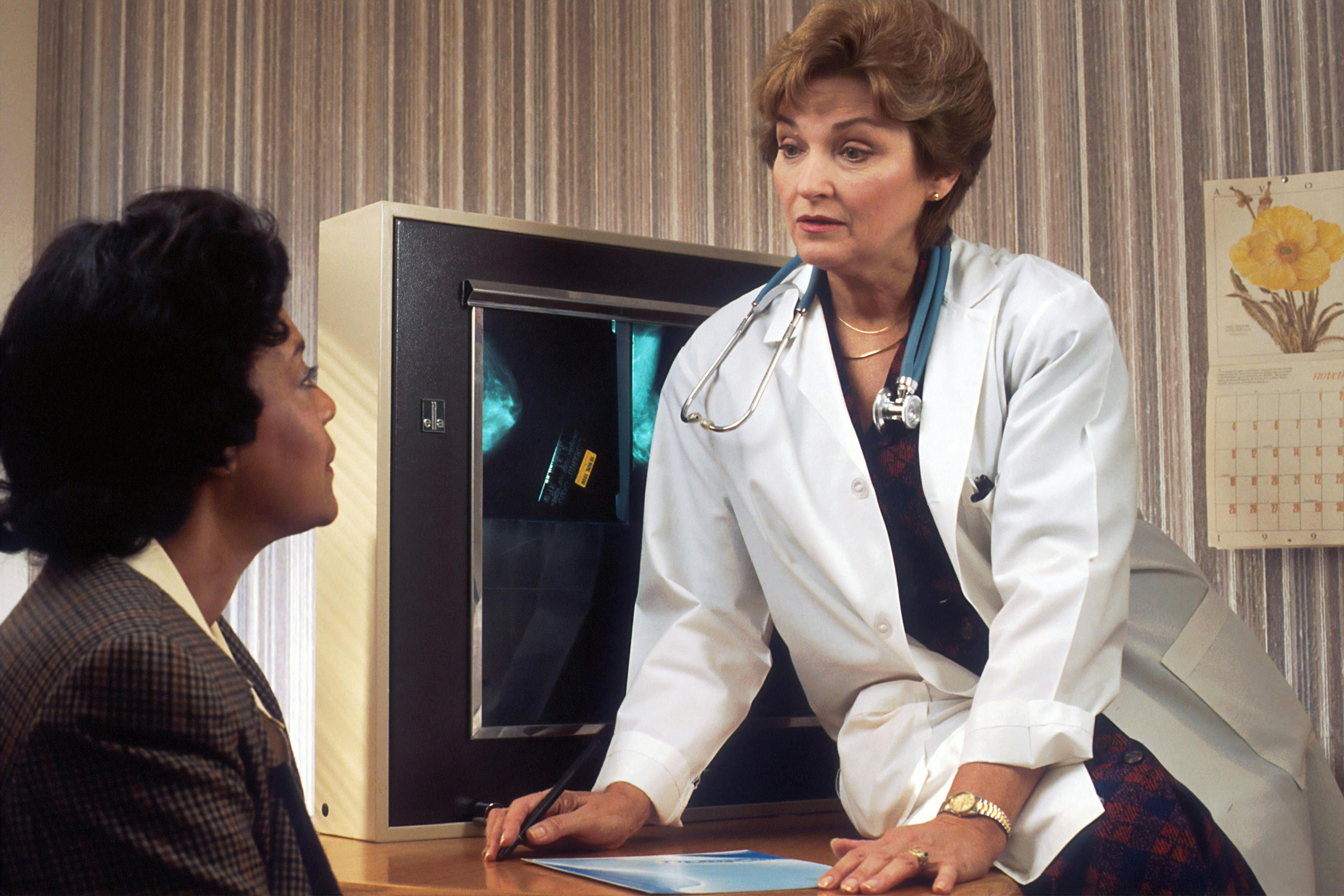 a doctor is talking to a patient in front of an x-ray machine .