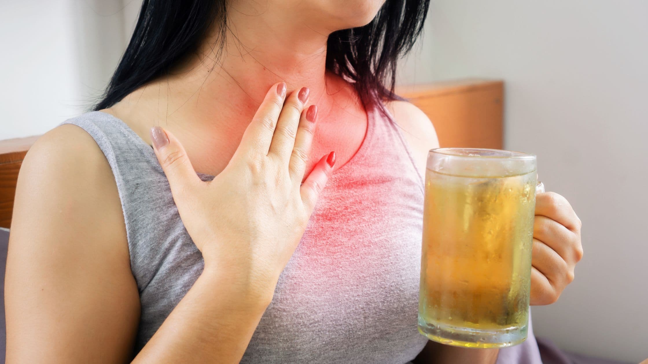 a woman is holding a cup of tea and has a sore throat .