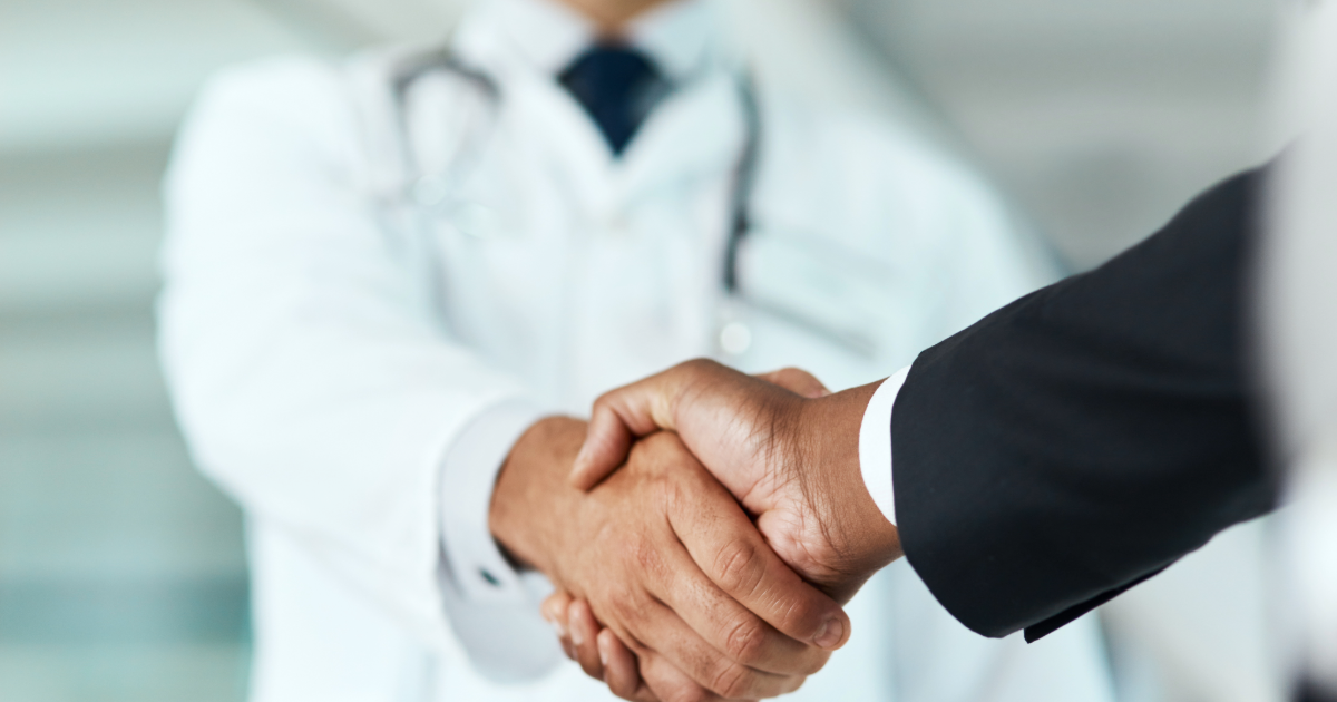 a doctor shakes hands with a man in a suit