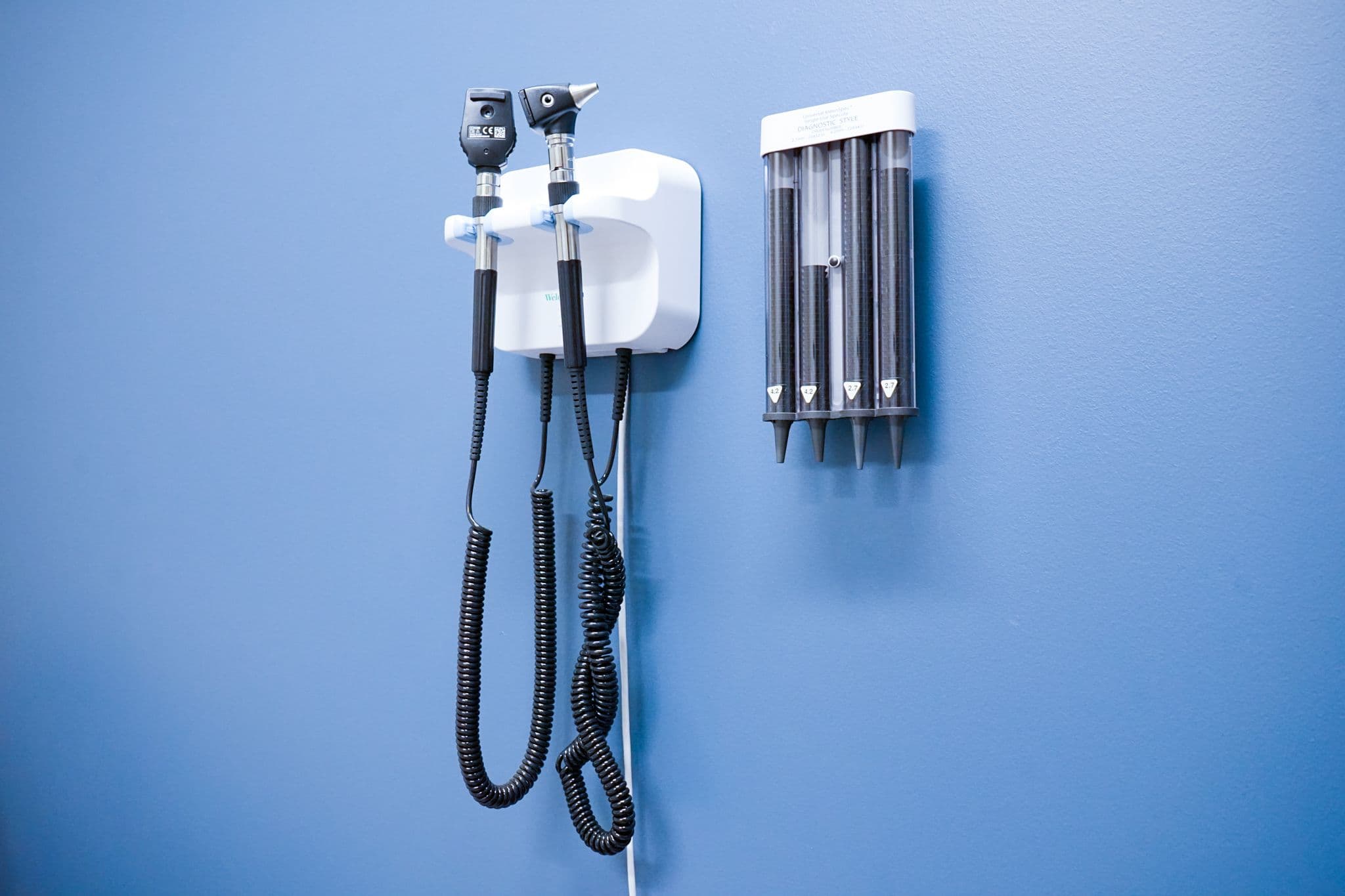 a stethoscope is hanging on a blue wall in a Restore Health & Wellness exam room .