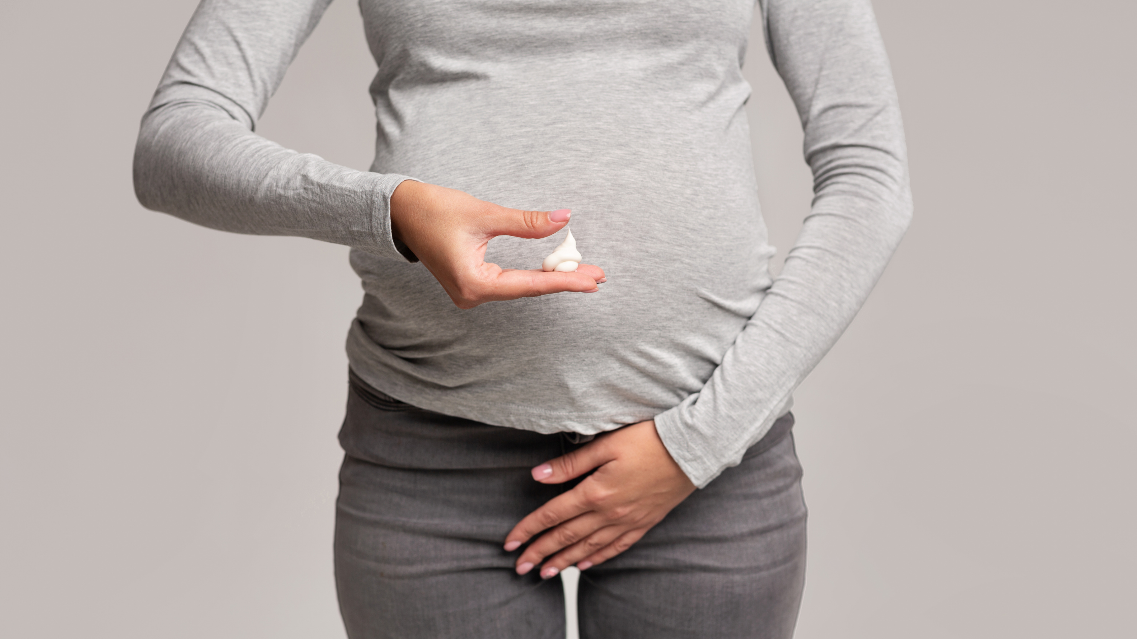 a pregnant woman holds a small white object in her hand