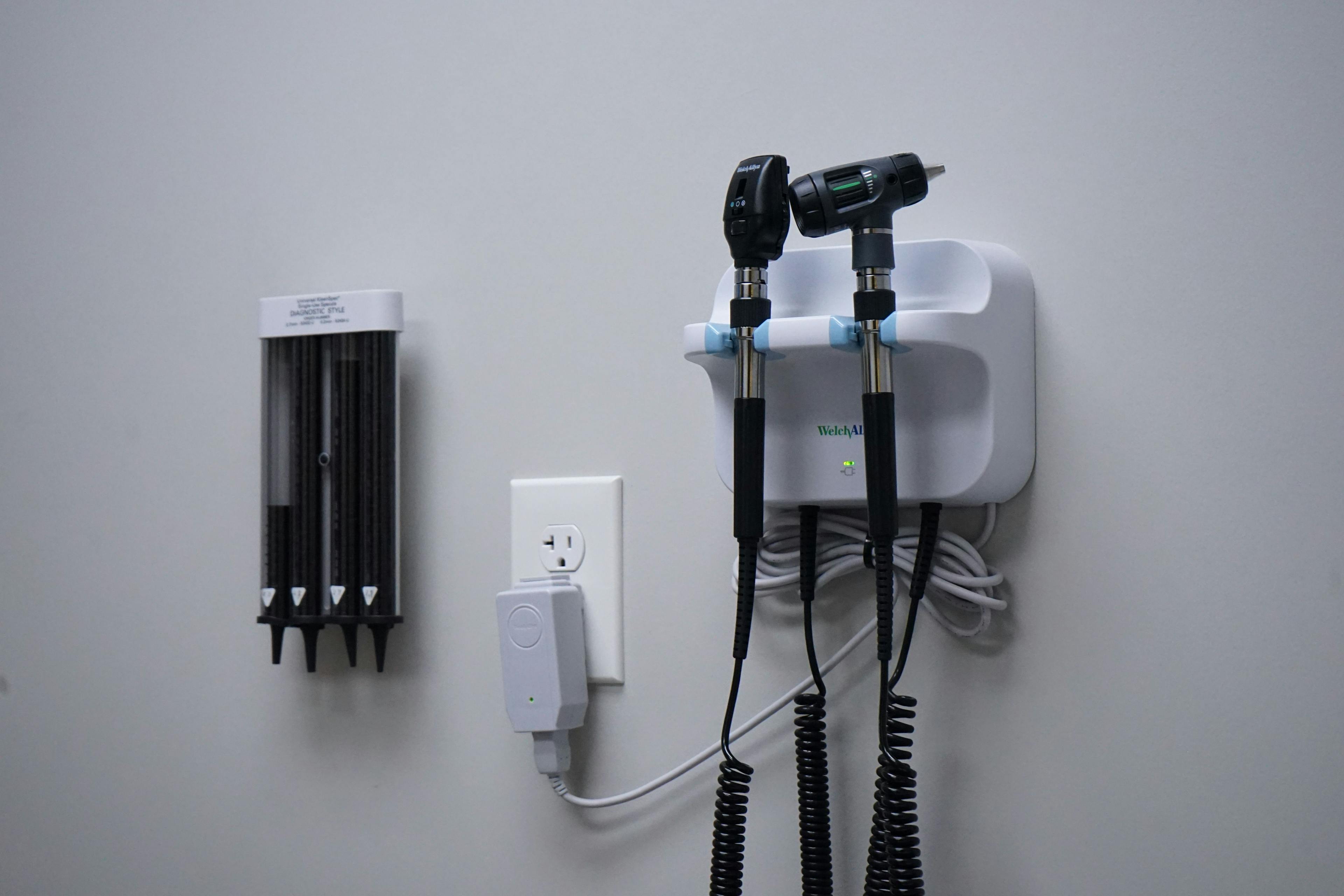 a pair of stethoscopes hanging on a wall next to a dispenser .