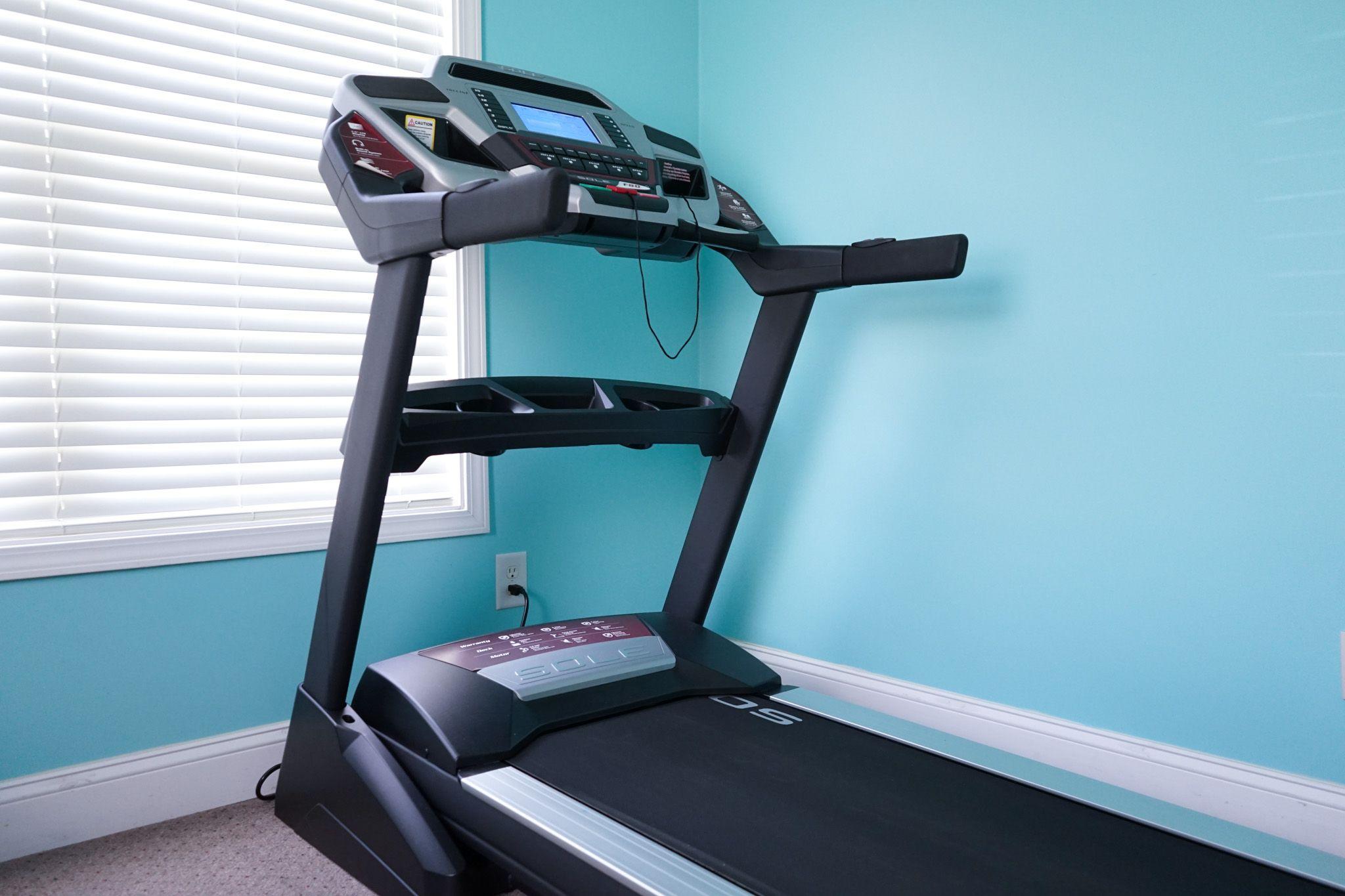 a treadmill is sitting in a room next to a window .