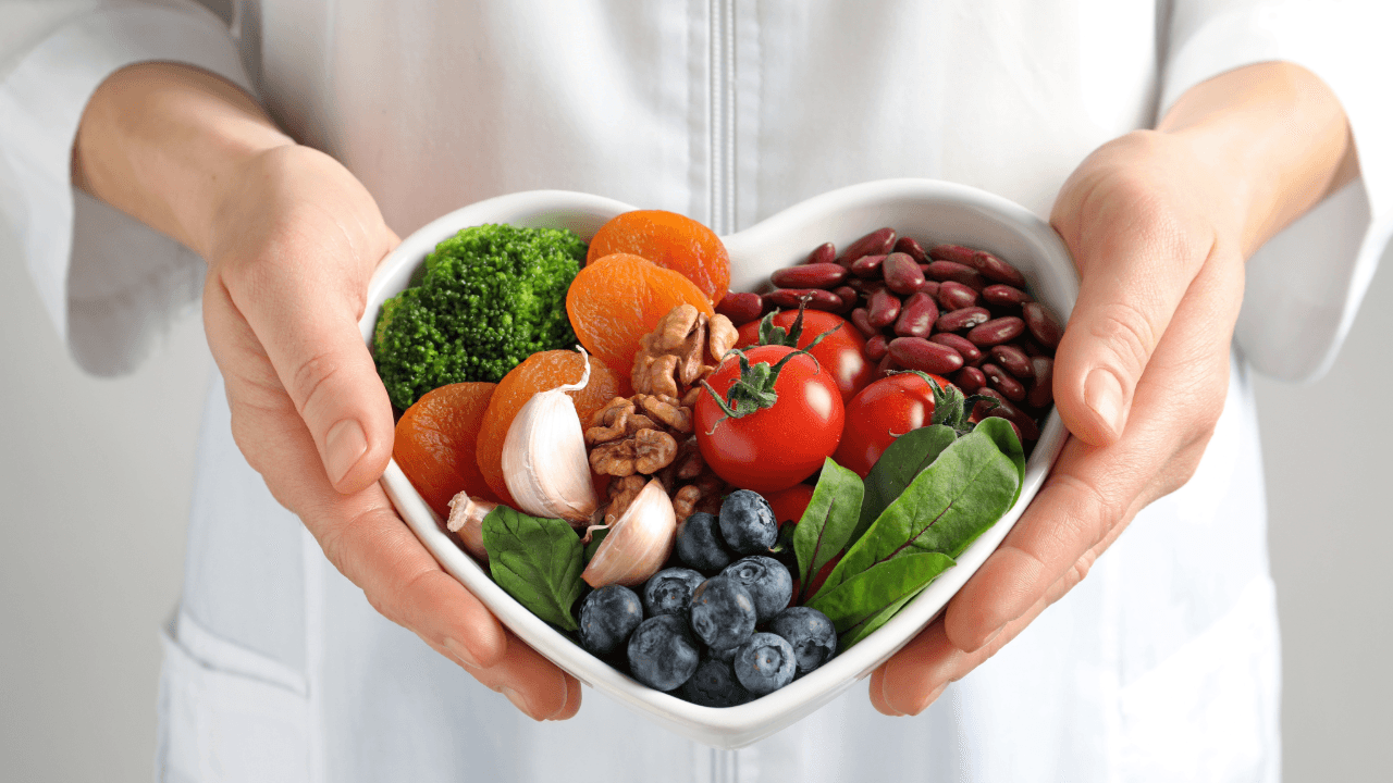 Good Nutrition: a person is holding a heart shaped bowl of fruits and vegetables