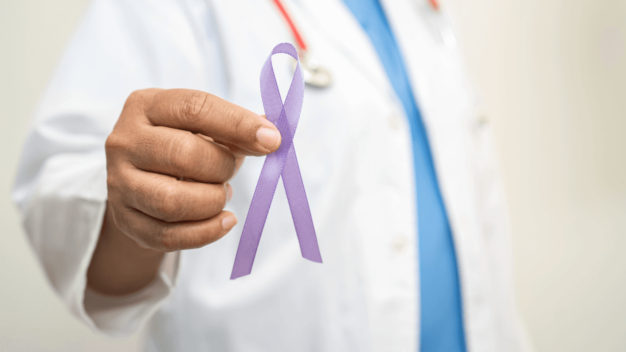 Pancreatic Cancer Awareness Day:  a doctor is holding a purple ribbon in his hand