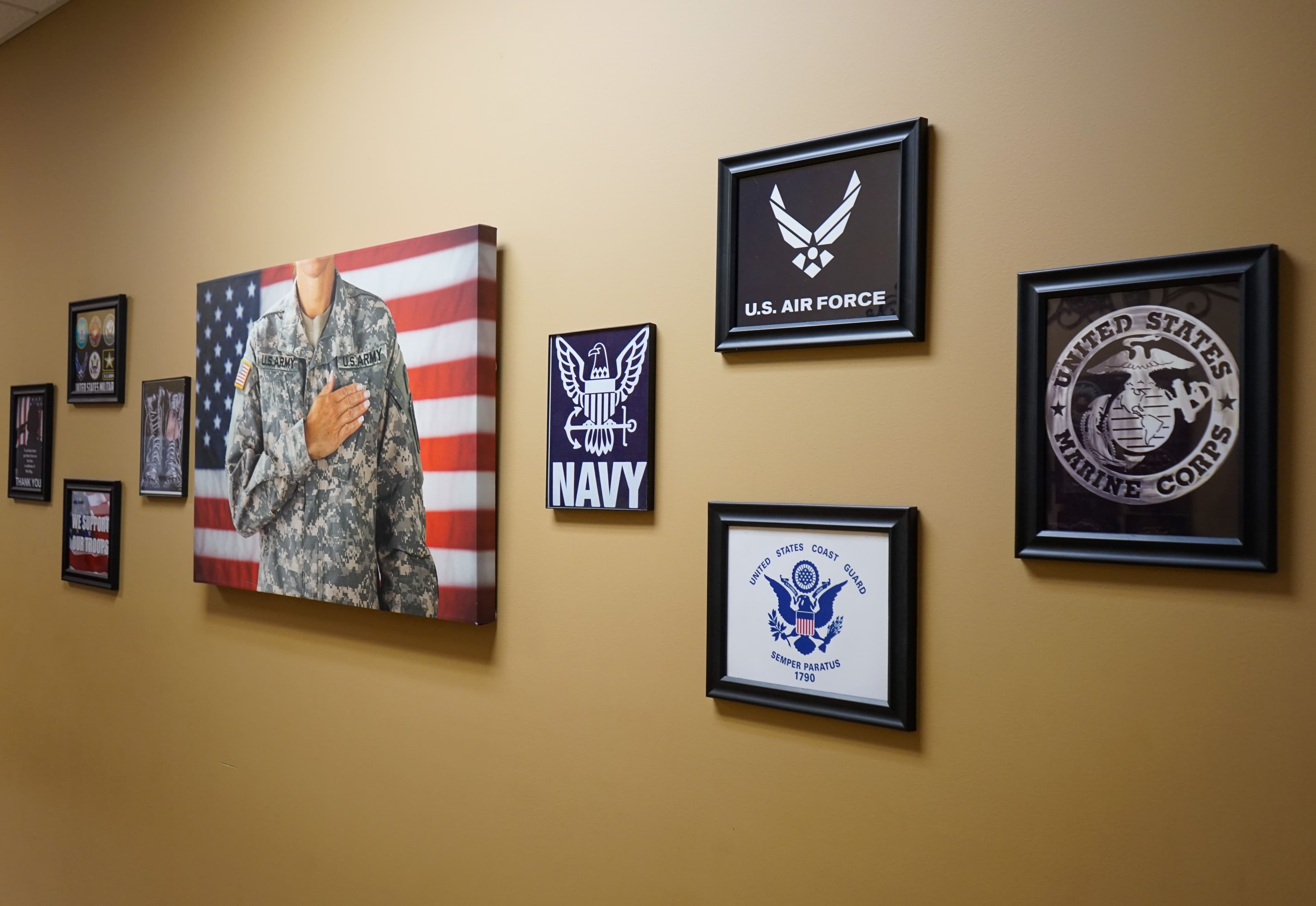 a wall with a painting of a soldier and various military emblems on it .