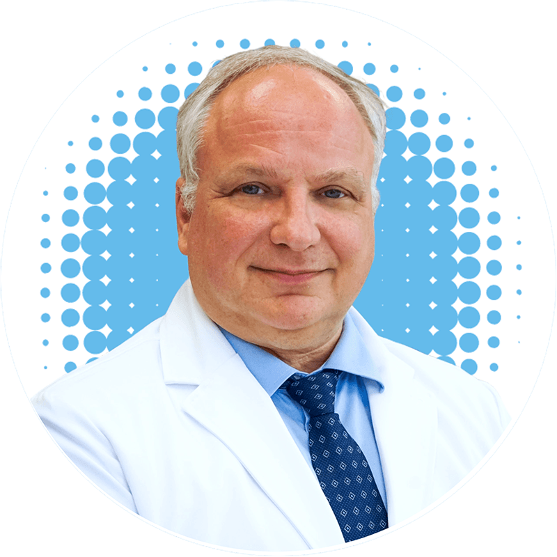 a man in a white coat and blue tie is smiling