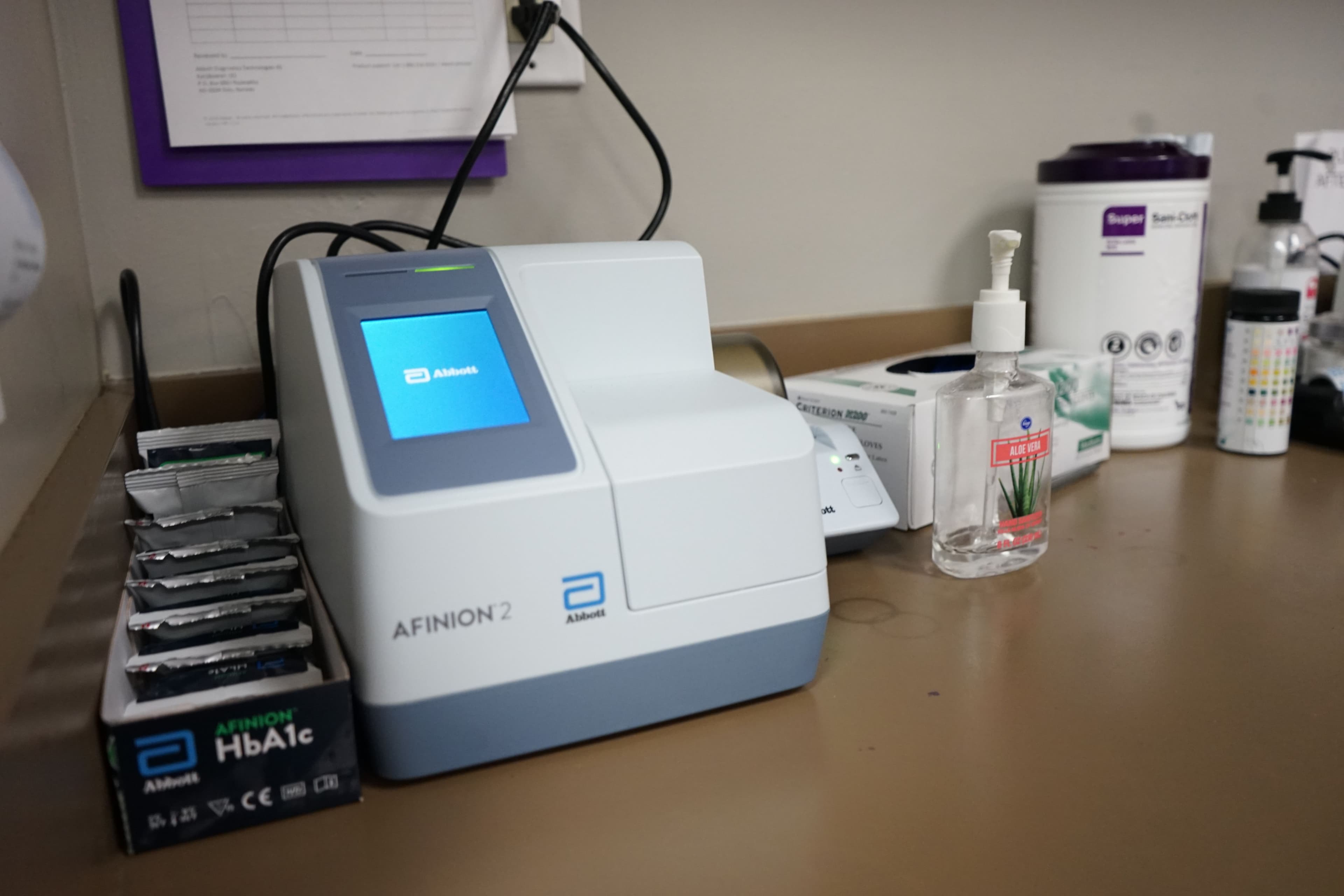 a machine is sitting on a table next to a bottle of hand sanitizer .