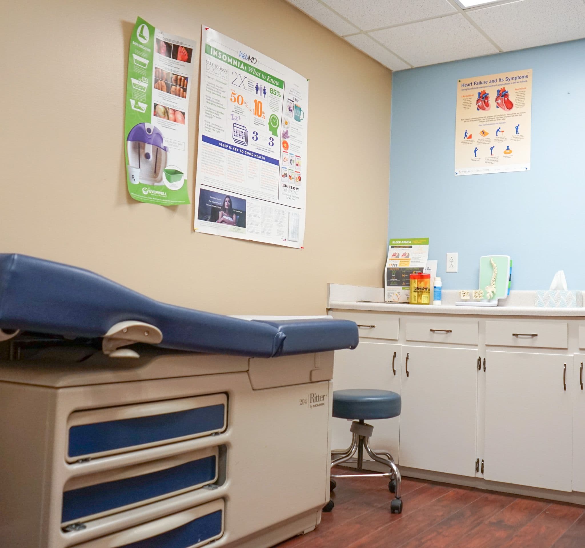 Middle Georgia Primary Care exam room with a blue exam table and a stool .