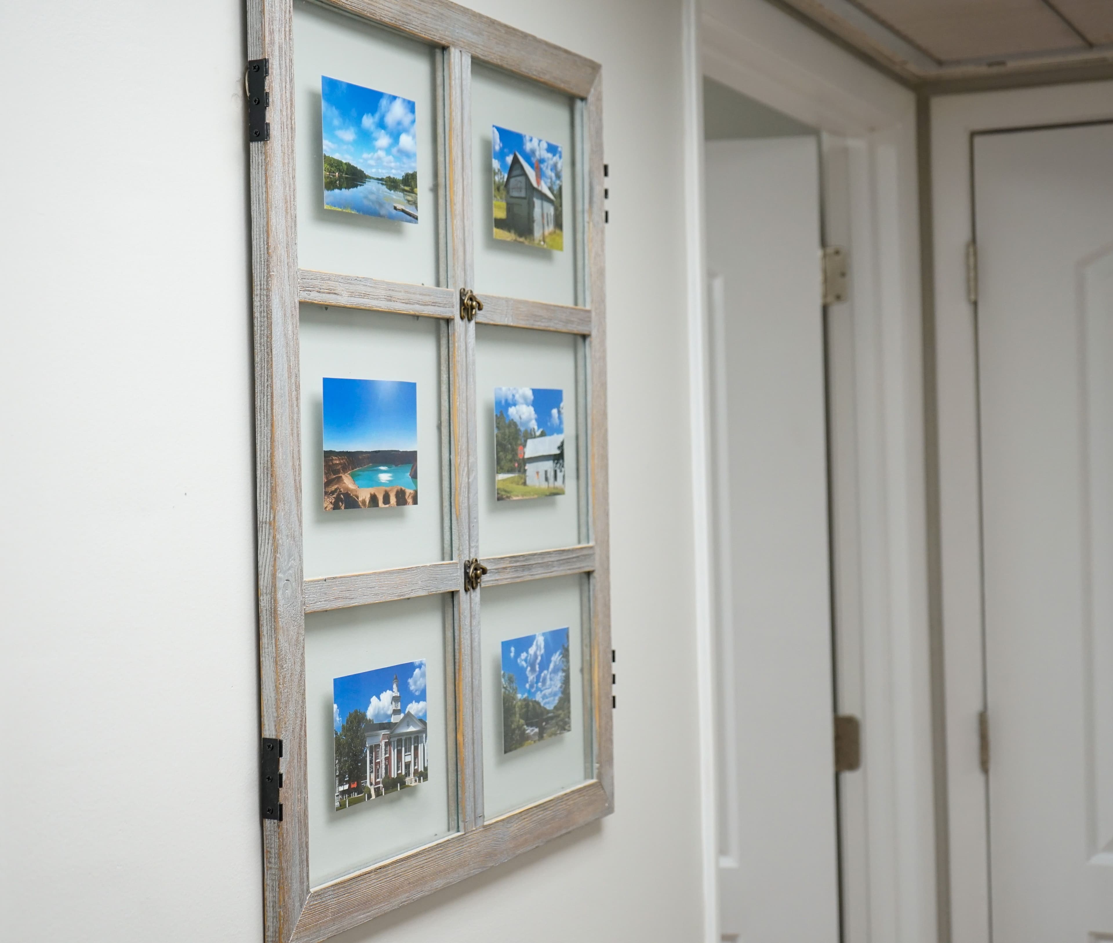 a picture frame made out of an old window is hanging on a wall .