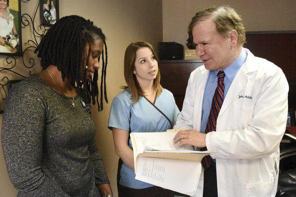 Dr. Antalis is talking to two nurses in an office .