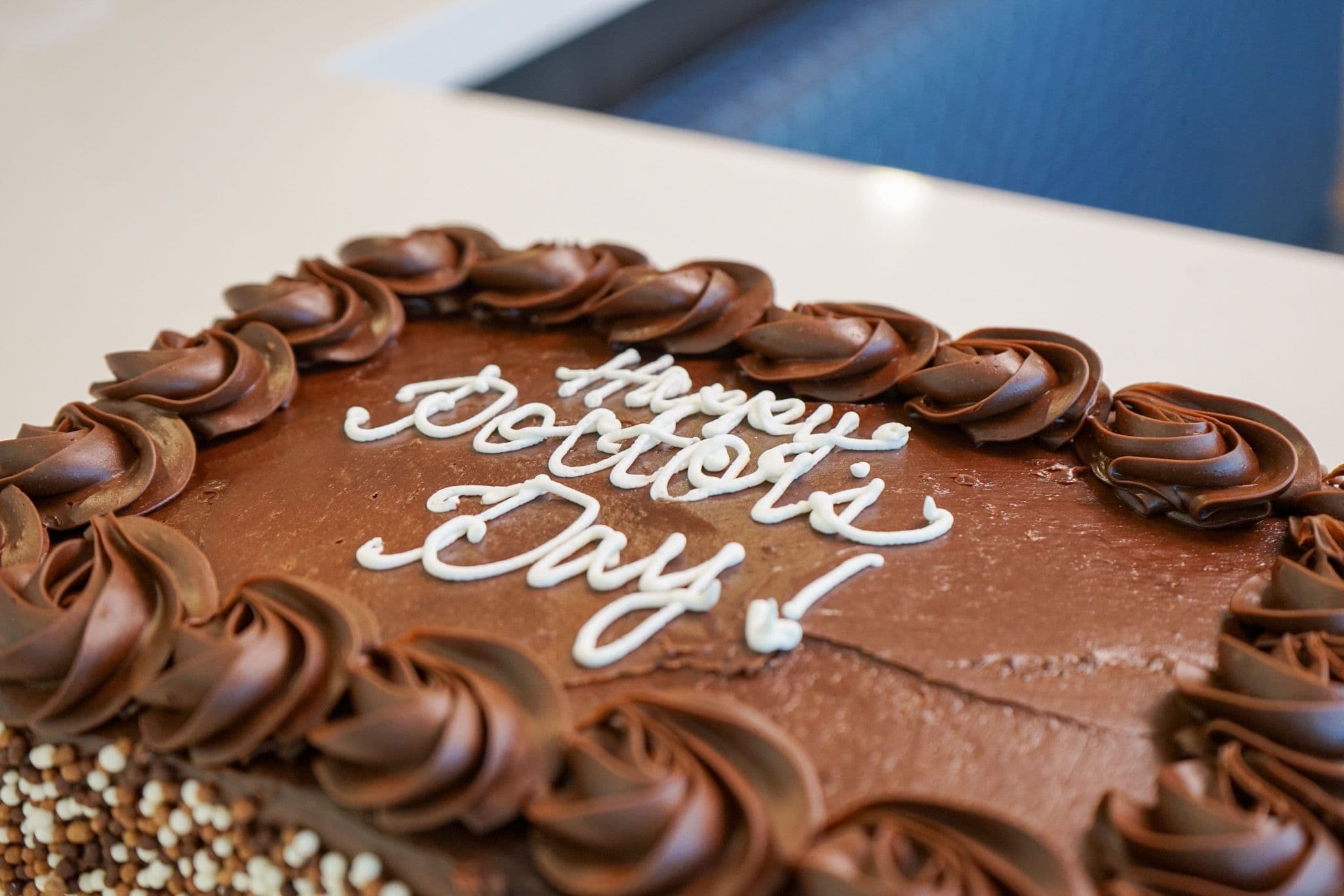 a chocolate cake with the words `` happy doctor 's day '' written on it .