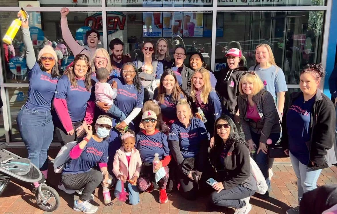 a group of people are posing for a picture in front of a building .