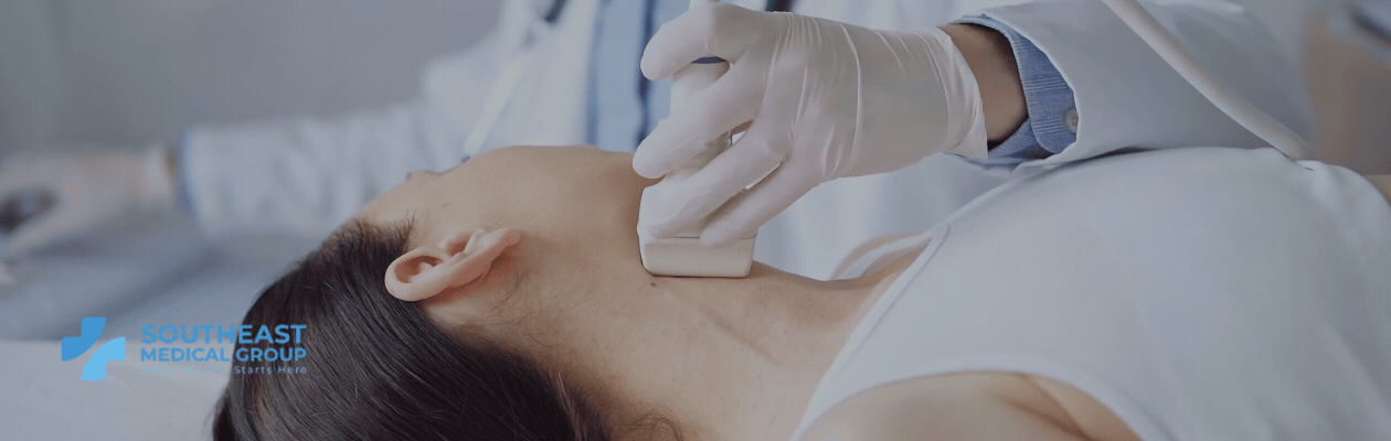 A medical professional performs an ultrasound on a patient's neck.