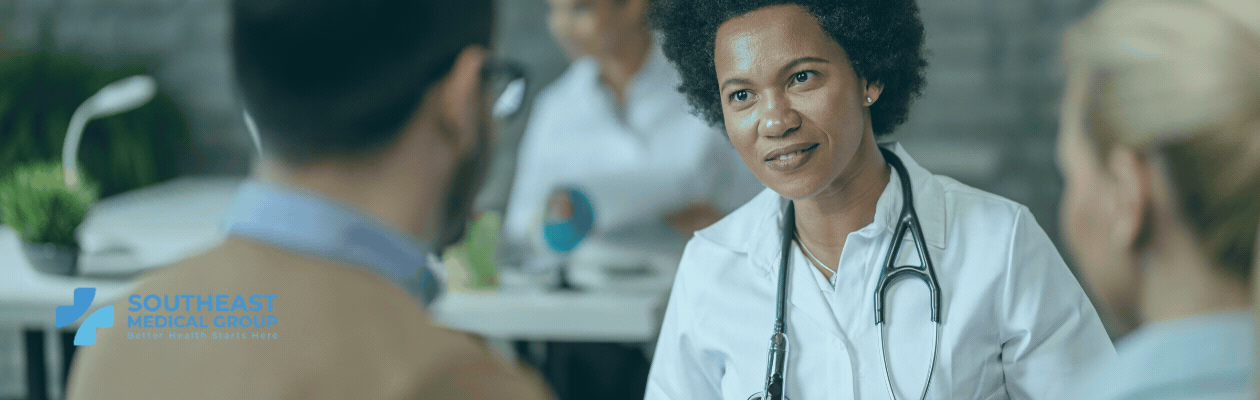 A female doctor with a stethoscope smiles while talking to a patient, with the "Southeast Medical Group" logo in the bottom left.