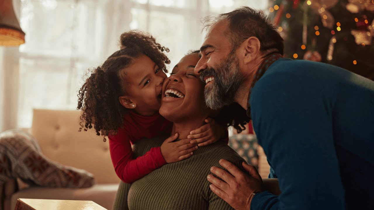 Family Holiday: a little girl kisses a woman on the cheek