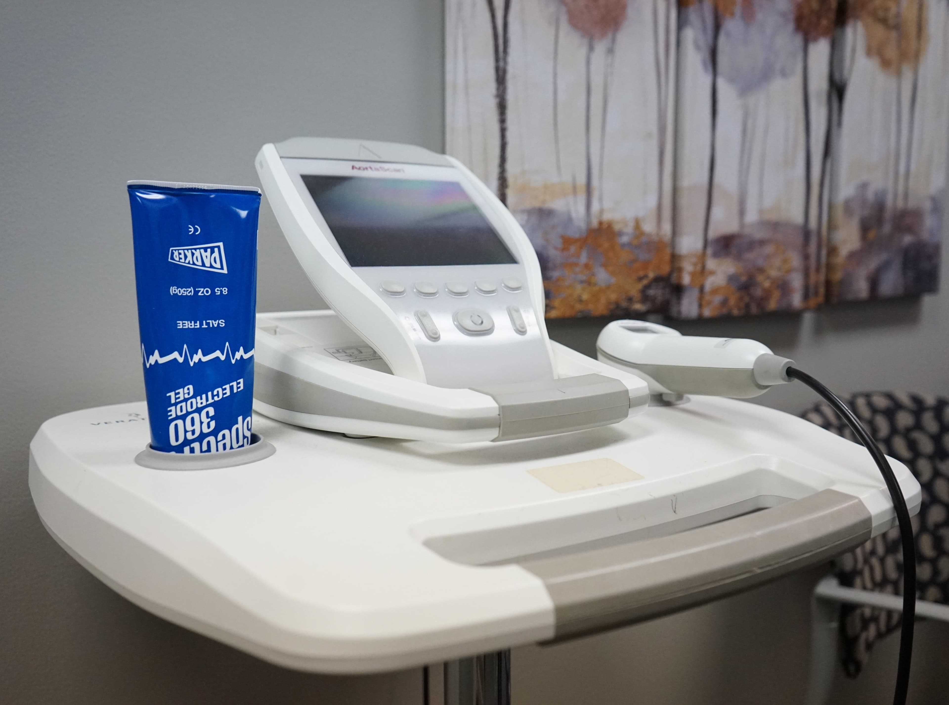 a machine is sitting on top of a table next to a can of electrode gel .