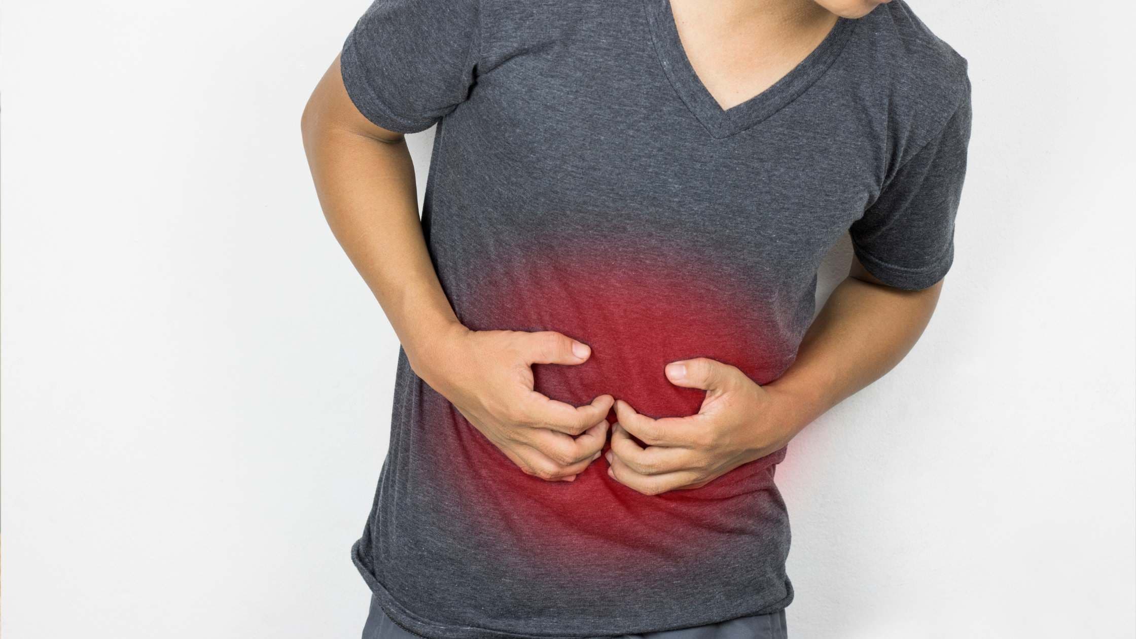 a man is holding his stomach in pain .