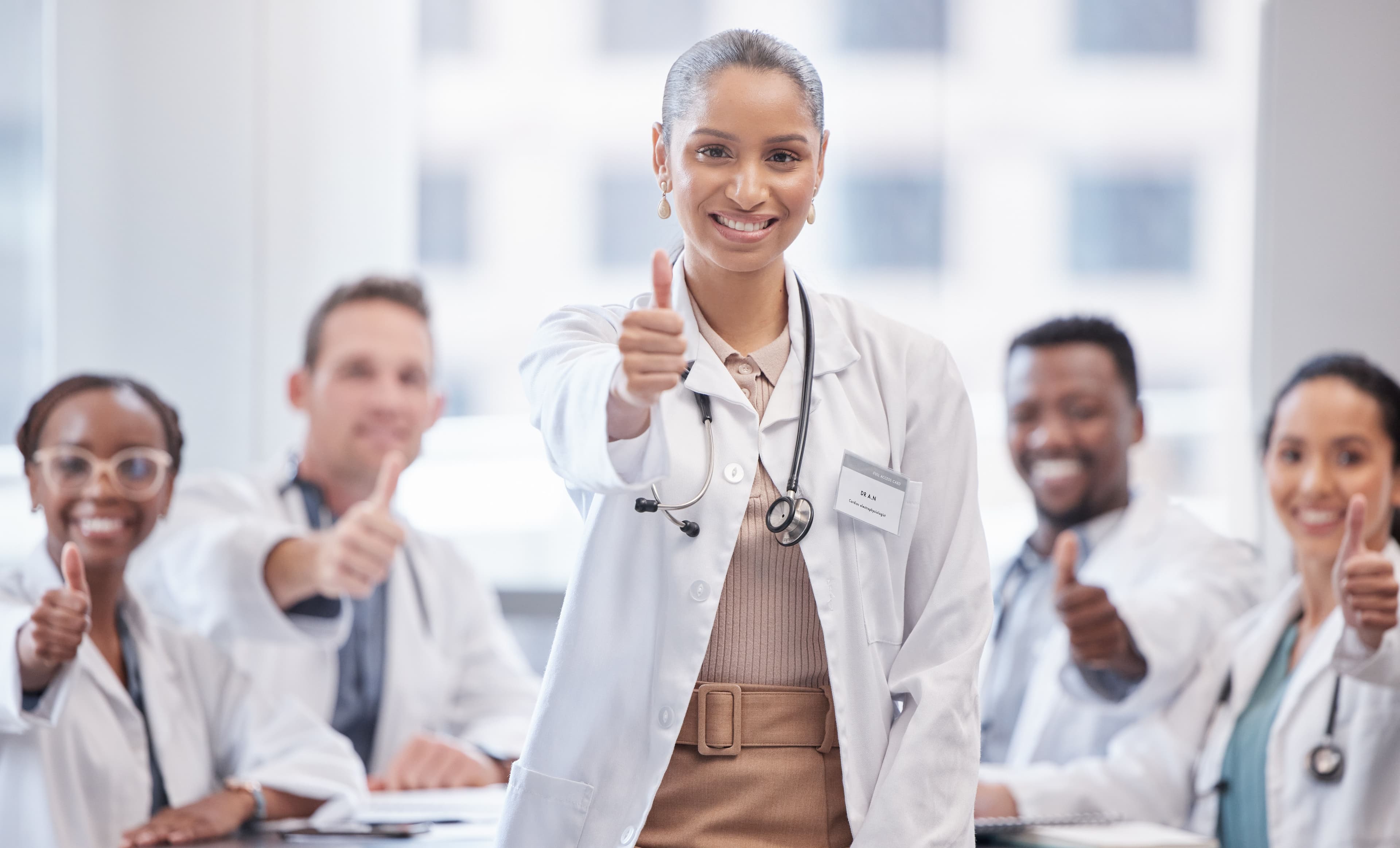 a group of doctors are giving each other a thumbs up .
