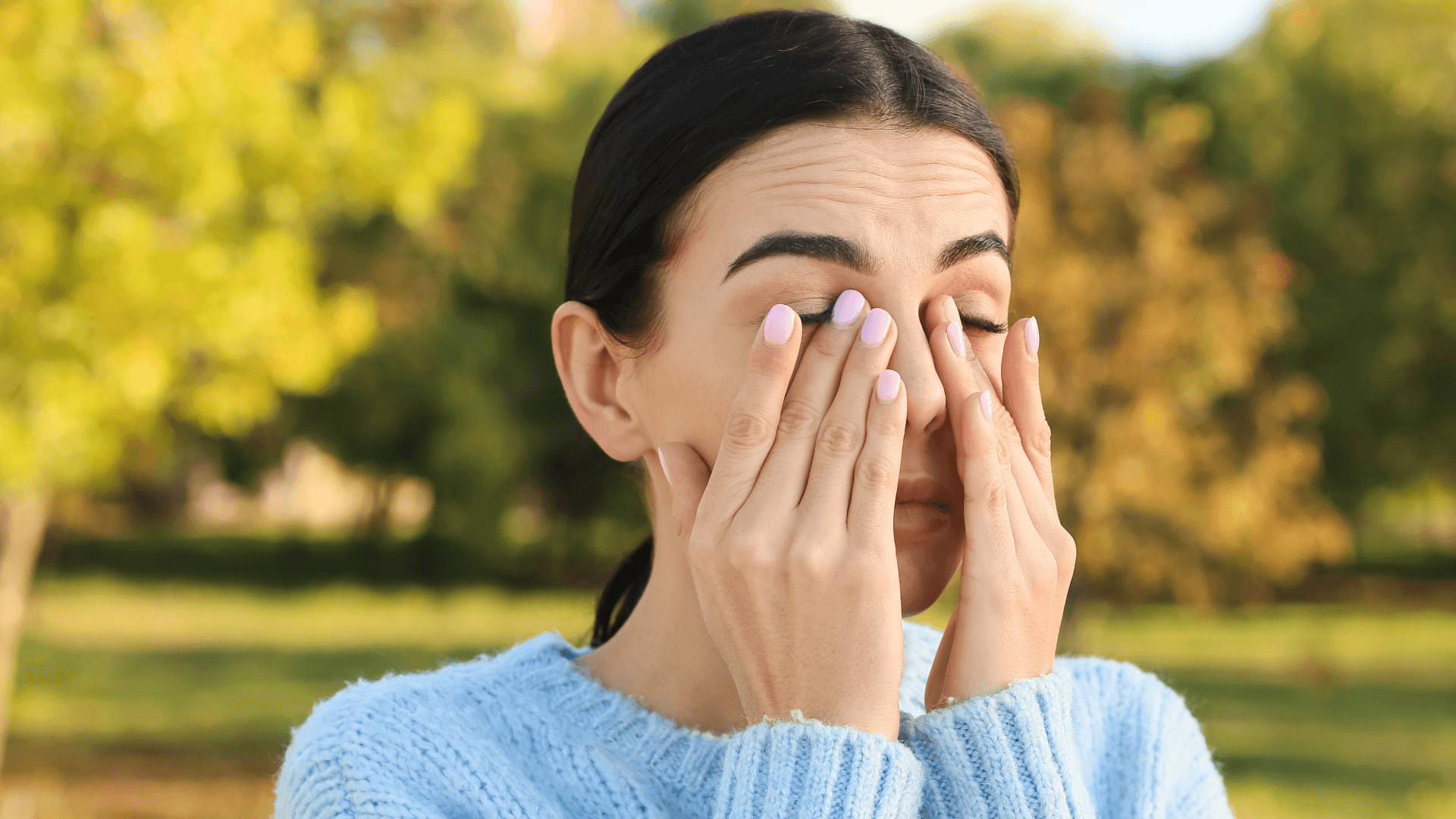 Allergies: A woman rubbing her eyes with both hands.
