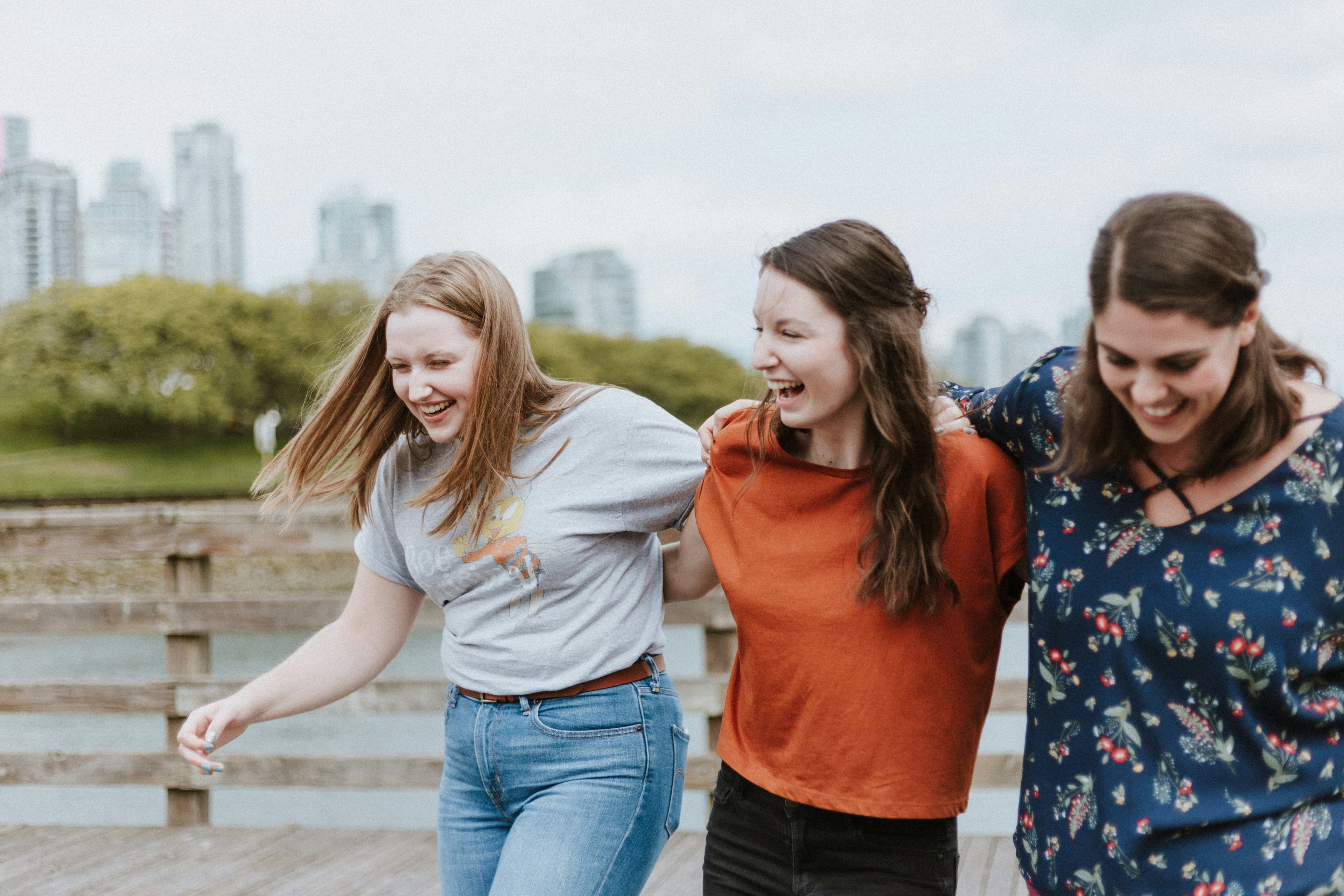 a group of women are hugging each other and smiling