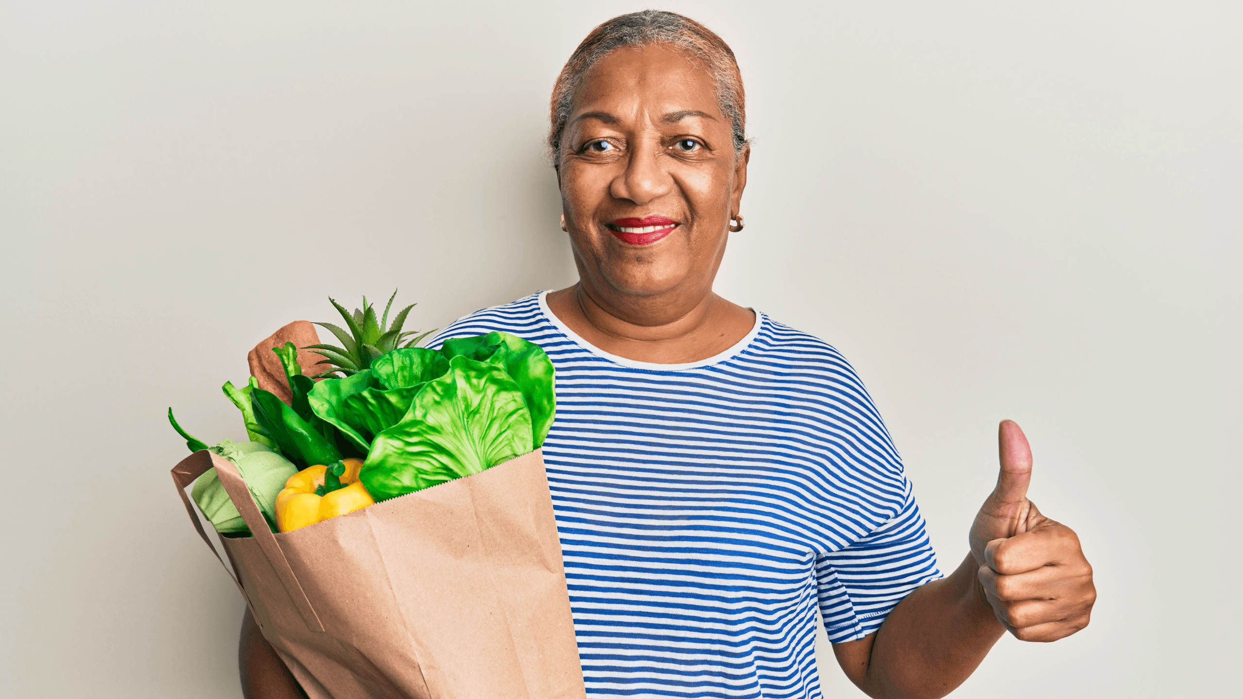 a woman is holding a bag of vegetables and giving a thumbs up